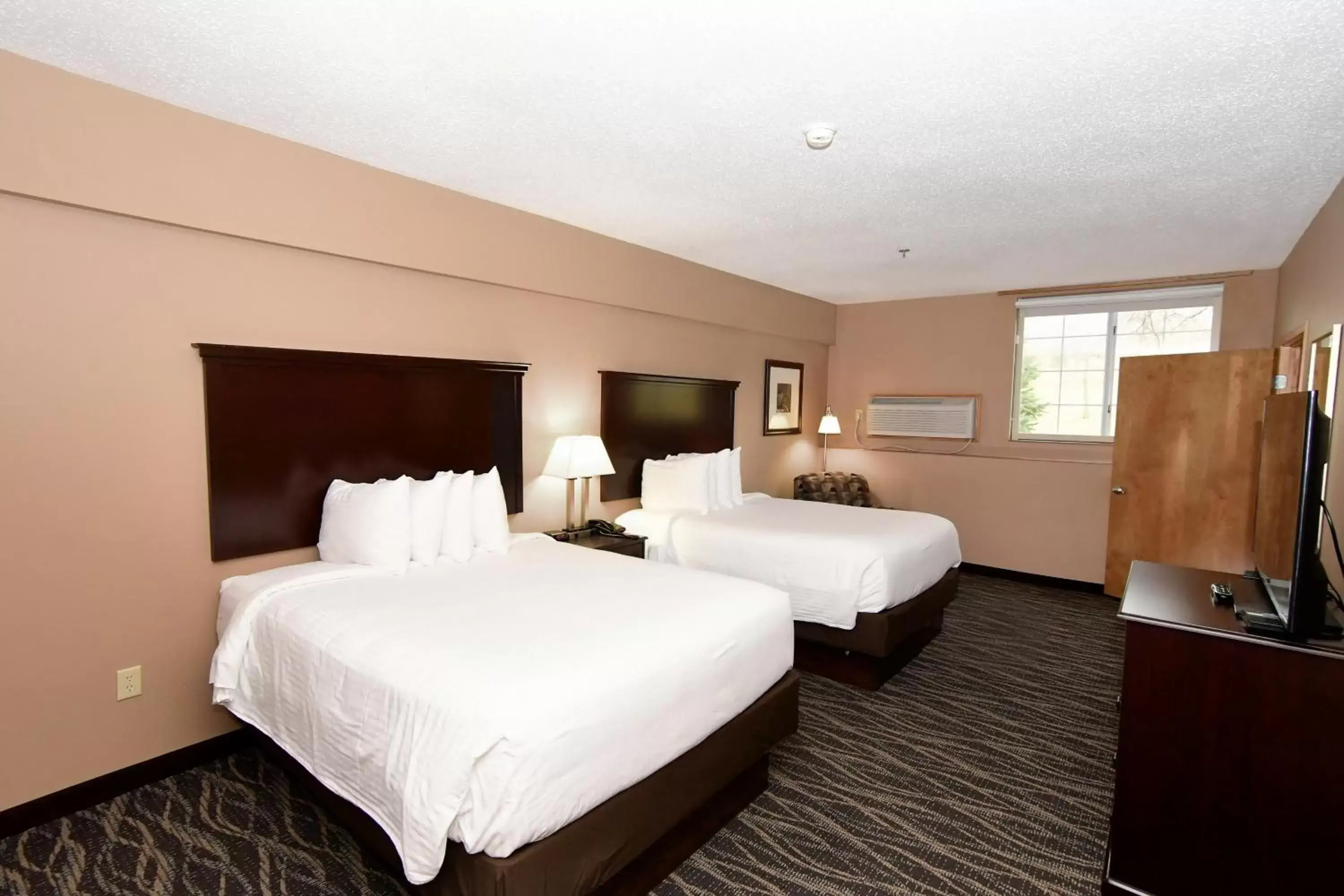 Bed in Cobblestone Inn & Suites - Denison | Majestic Hills