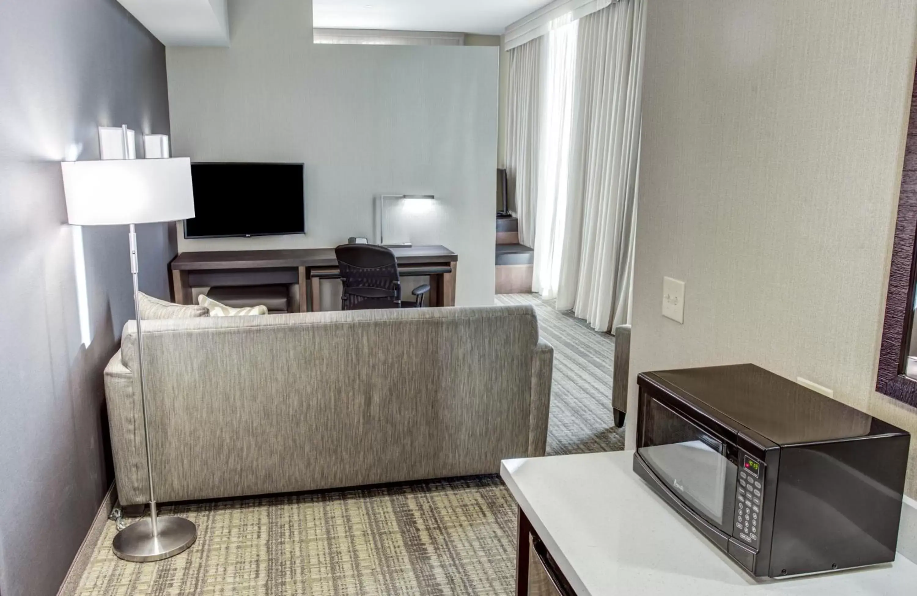 Living room, TV/Entertainment Center in Cambria Hotel Plano - Frisco