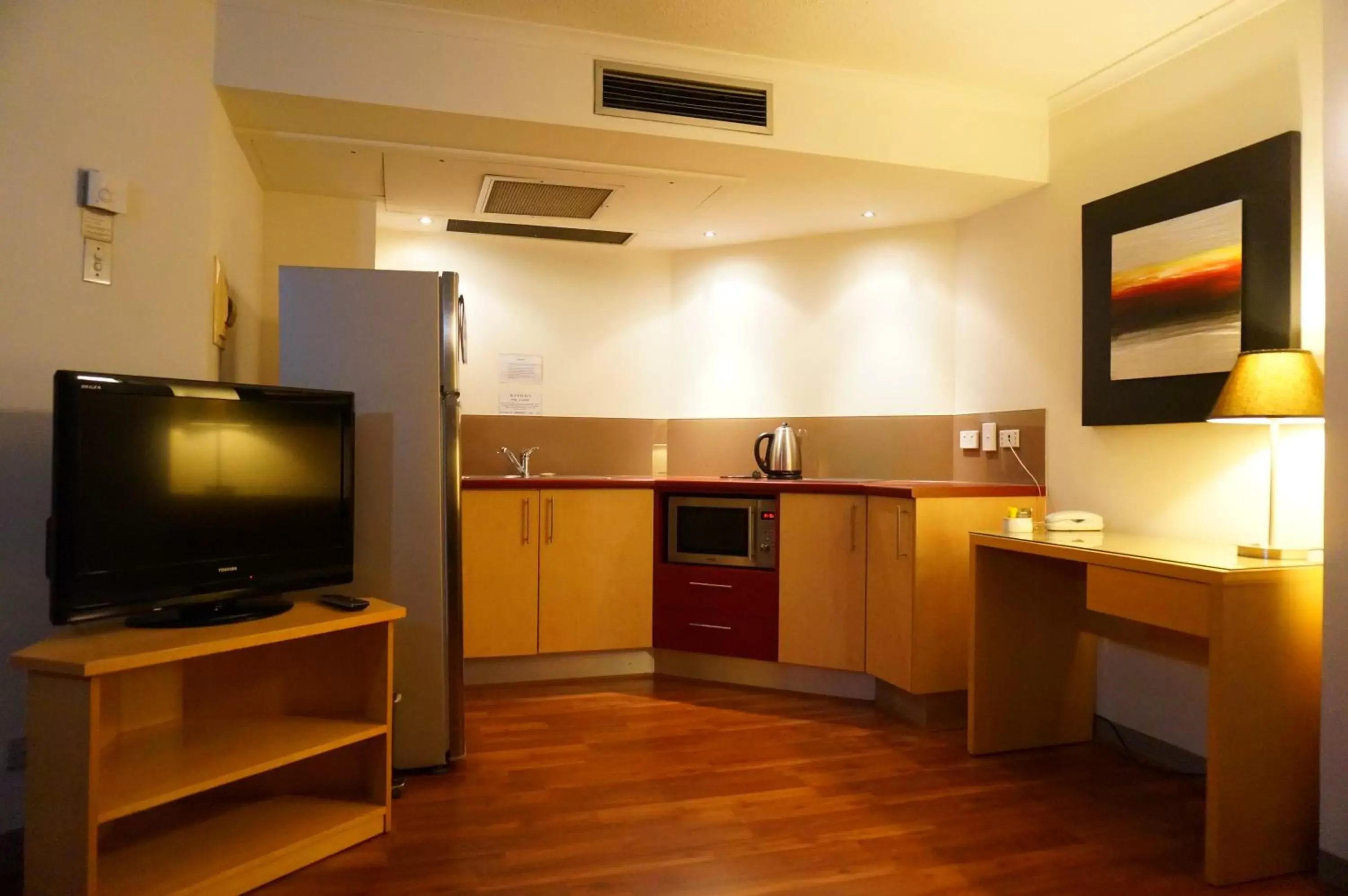 Kitchen or kitchenette, TV/Entertainment Center in Abbey On Roma Hotel & Apartments