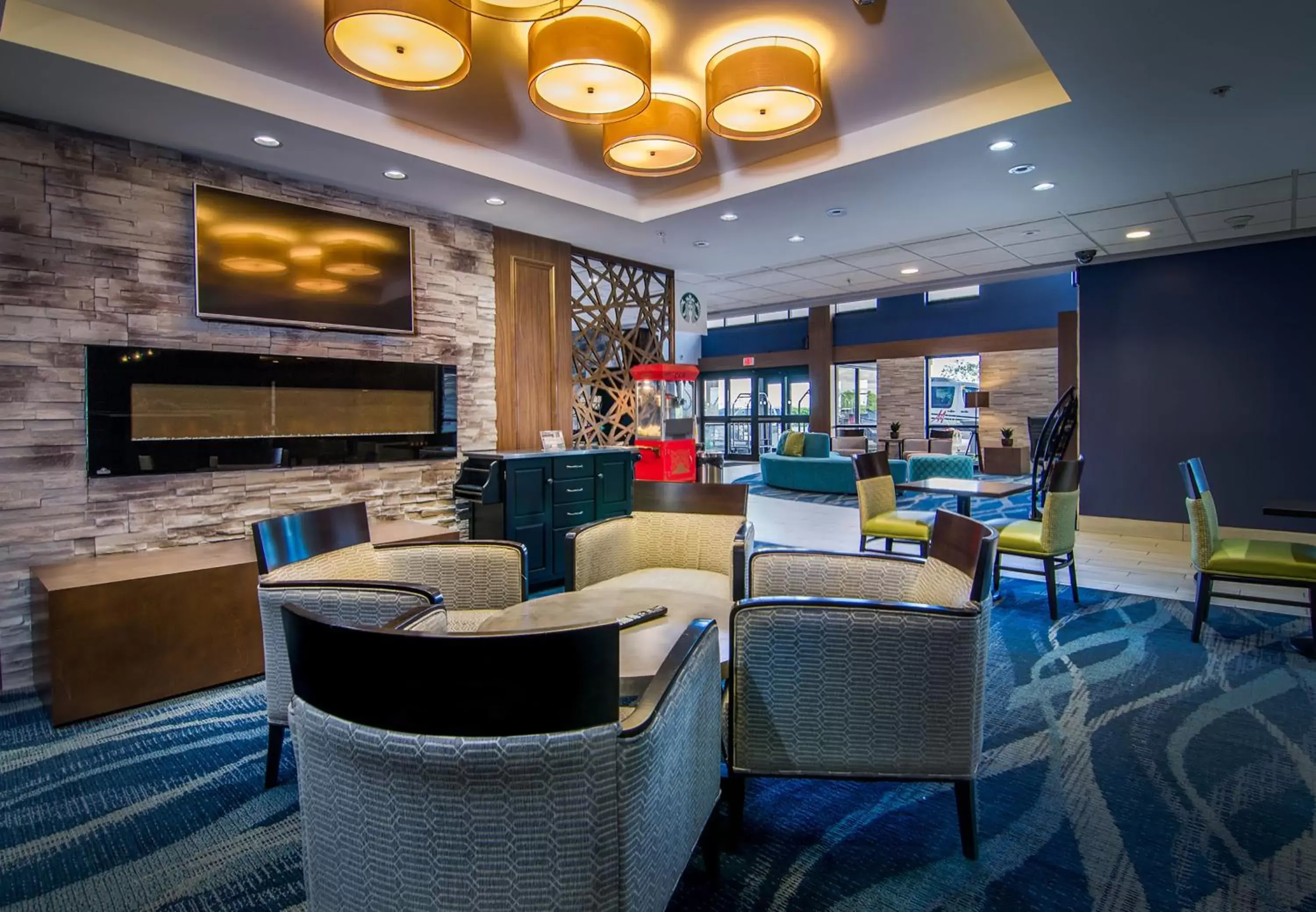 Communal lounge/ TV room in Holiday Inn & Suites Syracuse Airport - Liverpool, an IHG Hotel