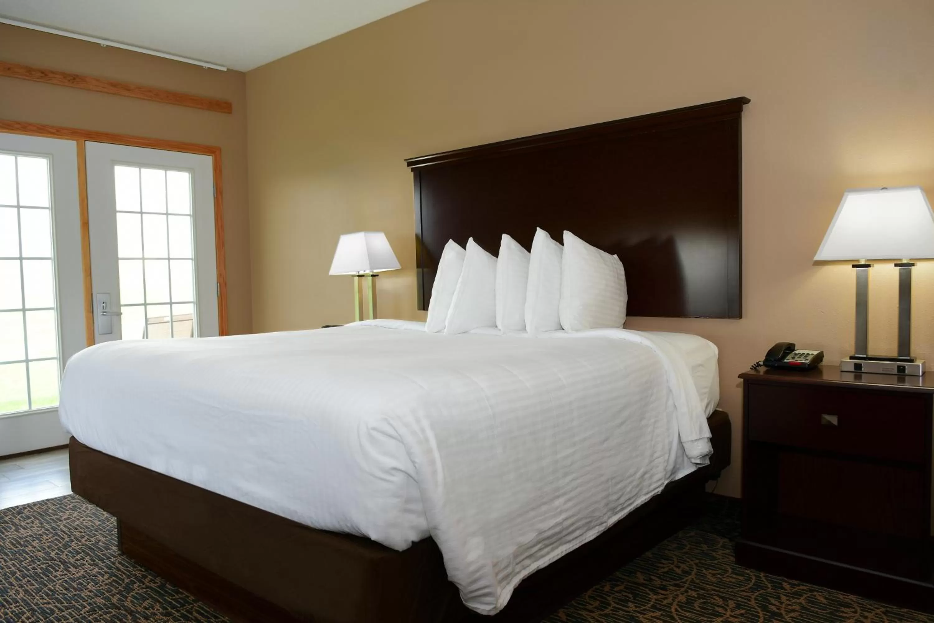 Bed in Cobblestone Inn & Suites - Denison | Majestic Hills