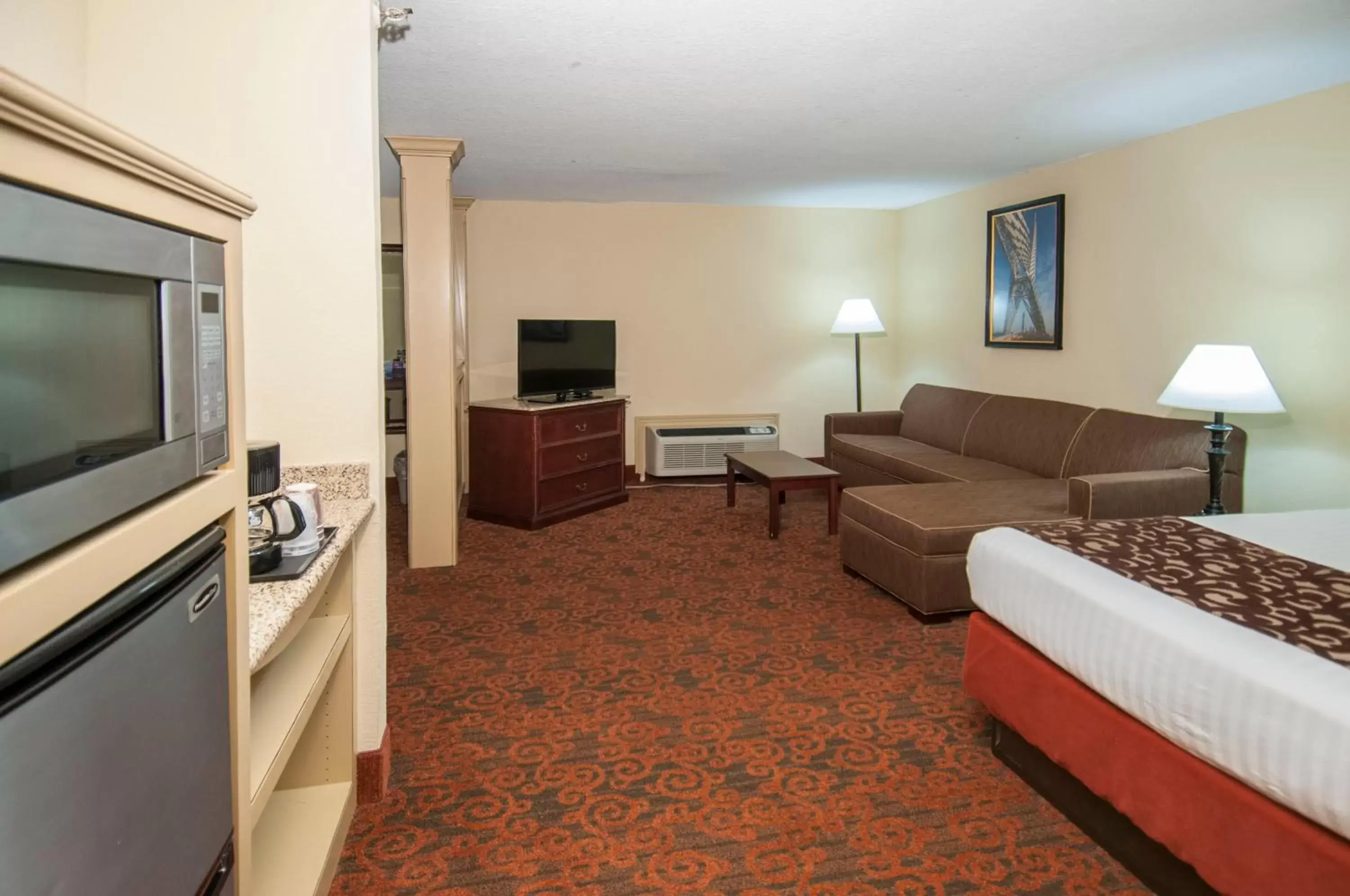 Bed, TV/Entertainment Center in Governors Suites Hotel Oklahoma City Airport Area