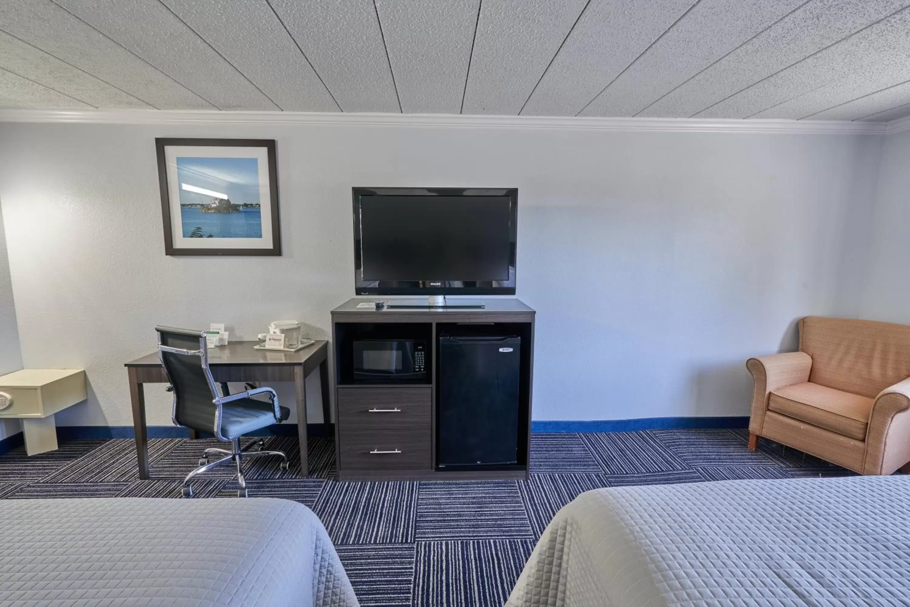 Bed, TV/Entertainment Center in The Admiralty Inn & Suites