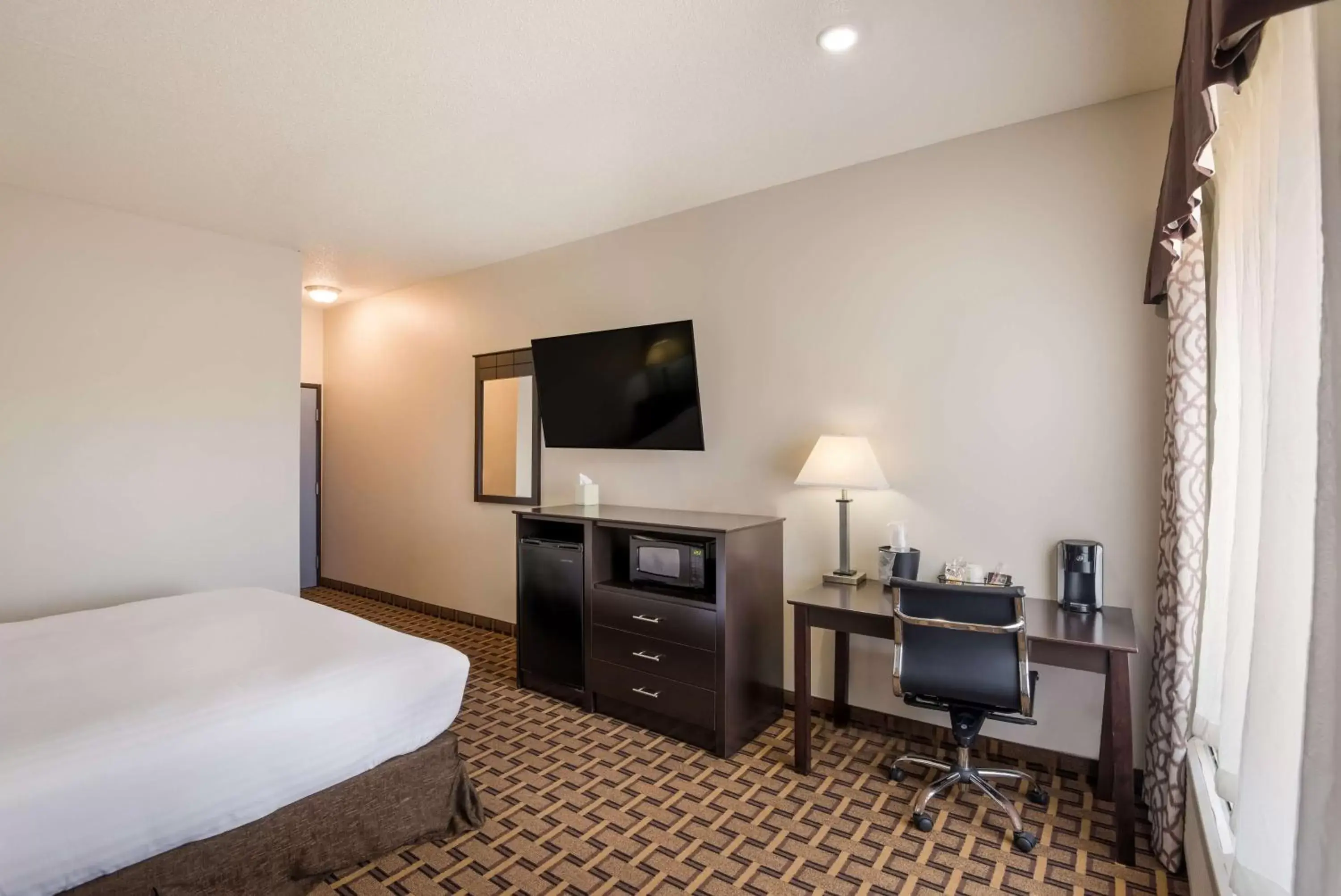 Bedroom, TV/Entertainment Center in SureStay Plus Hotel by Best Western Coralville Iowa City