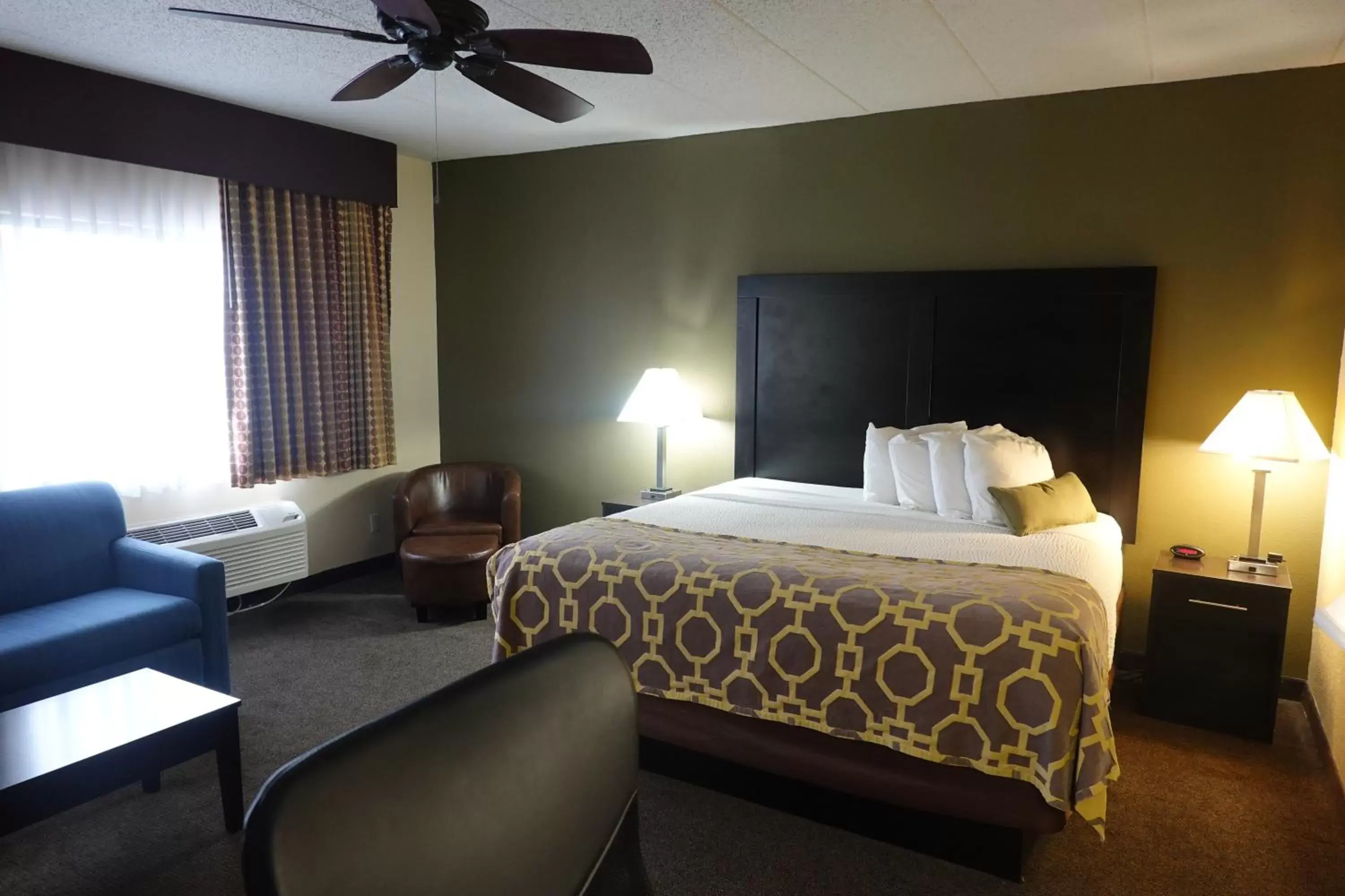 Seating area, Bed in Baymont by Wyndham Janesville