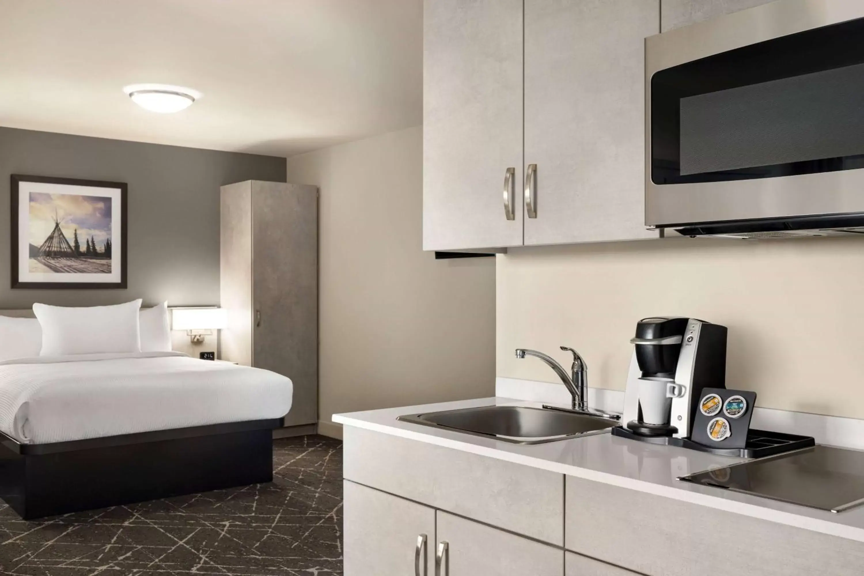 Bed, Kitchen/Kitchenette in Microtel Inn & Suites Montreal Airport-Dorval QC