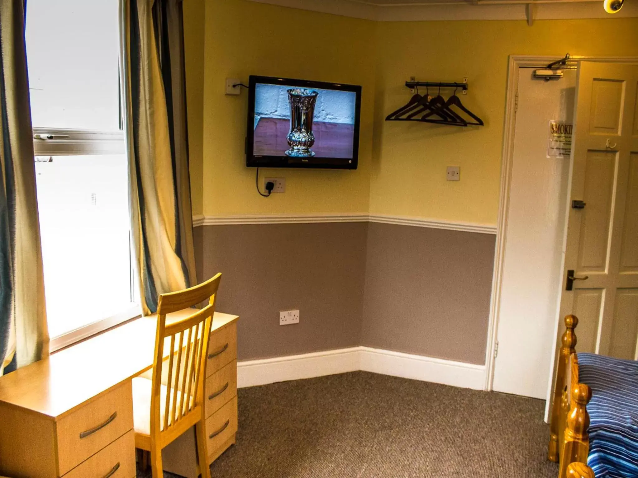 Bedroom, TV/Entertainment Center in Cricklewood Lodge Hotel