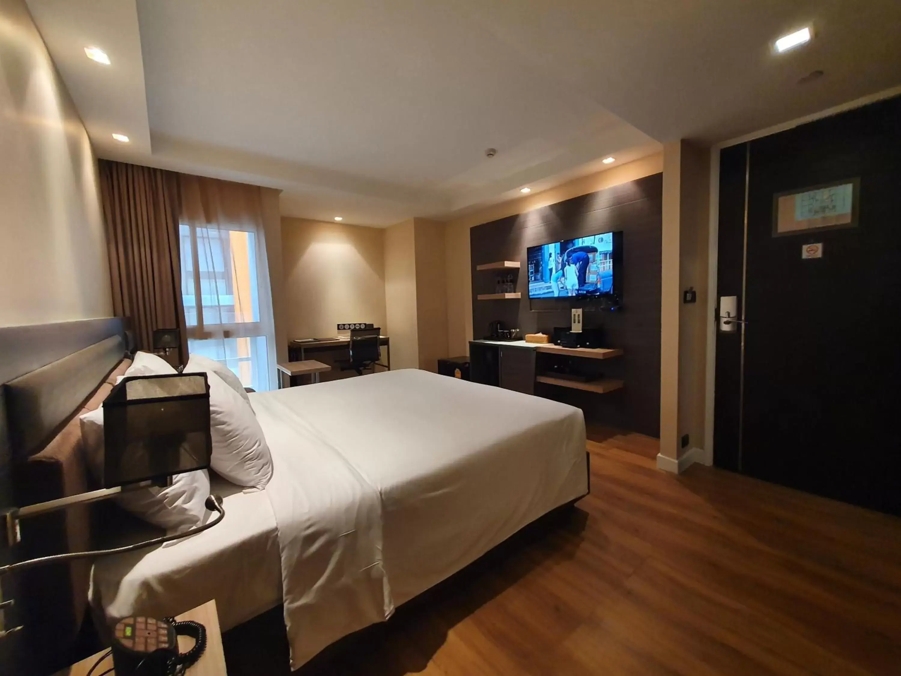 Bed, TV/Entertainment Center in Amora NeoLuxe Suites Hotel