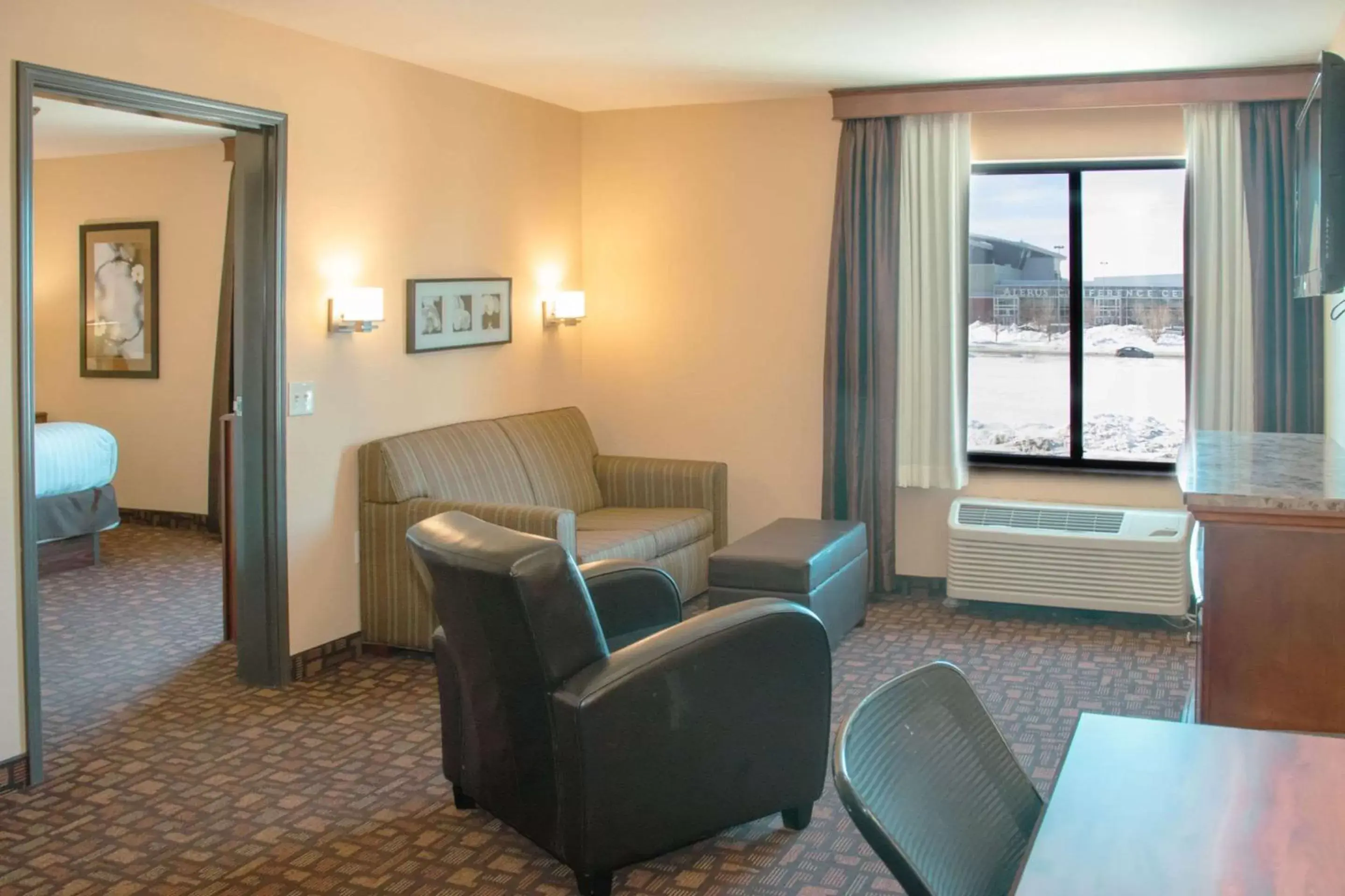 Bedroom, Seating Area in Expressway Suites of Grand Forks