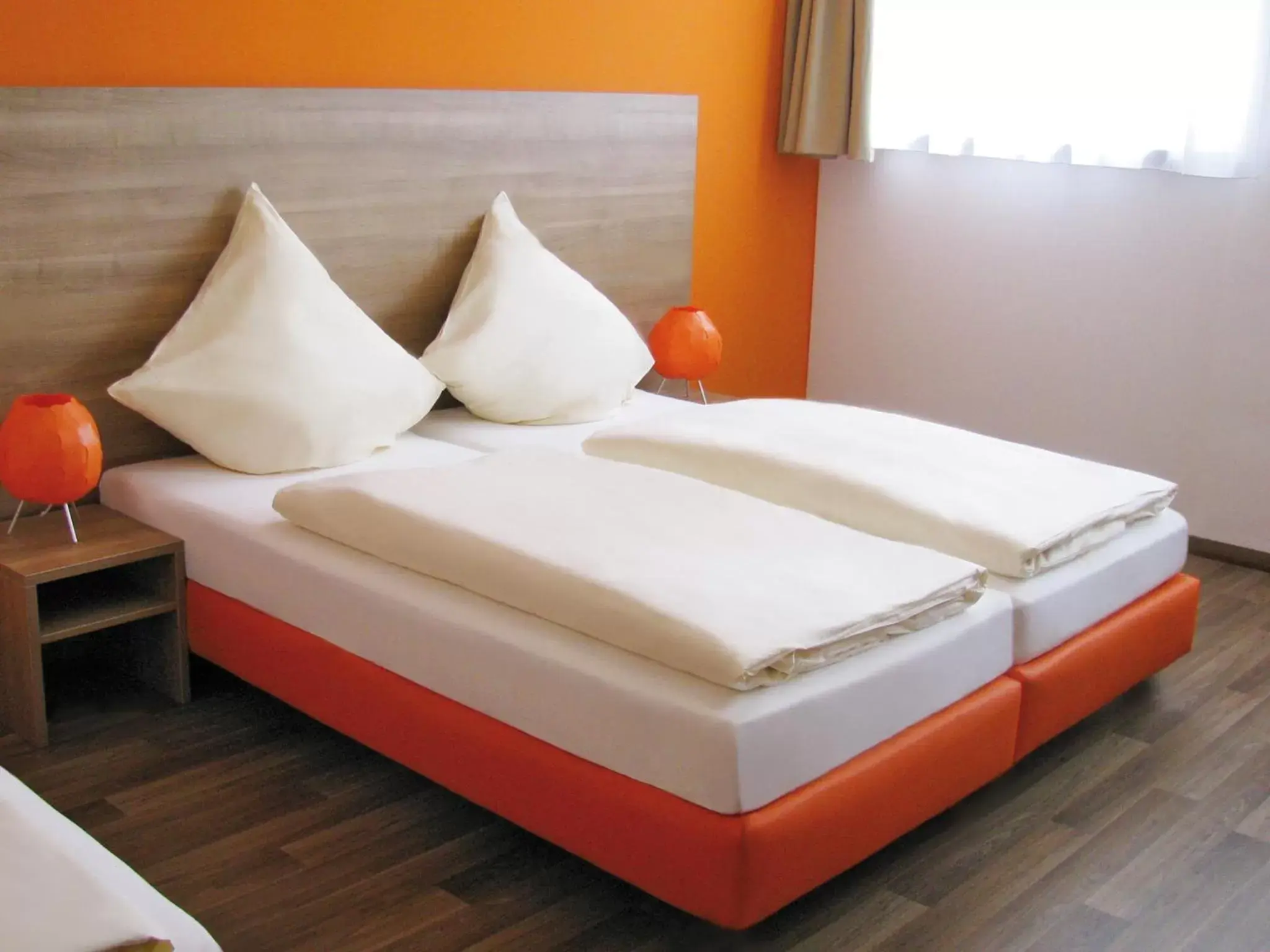 Bed in Orange Hotel und Apartments