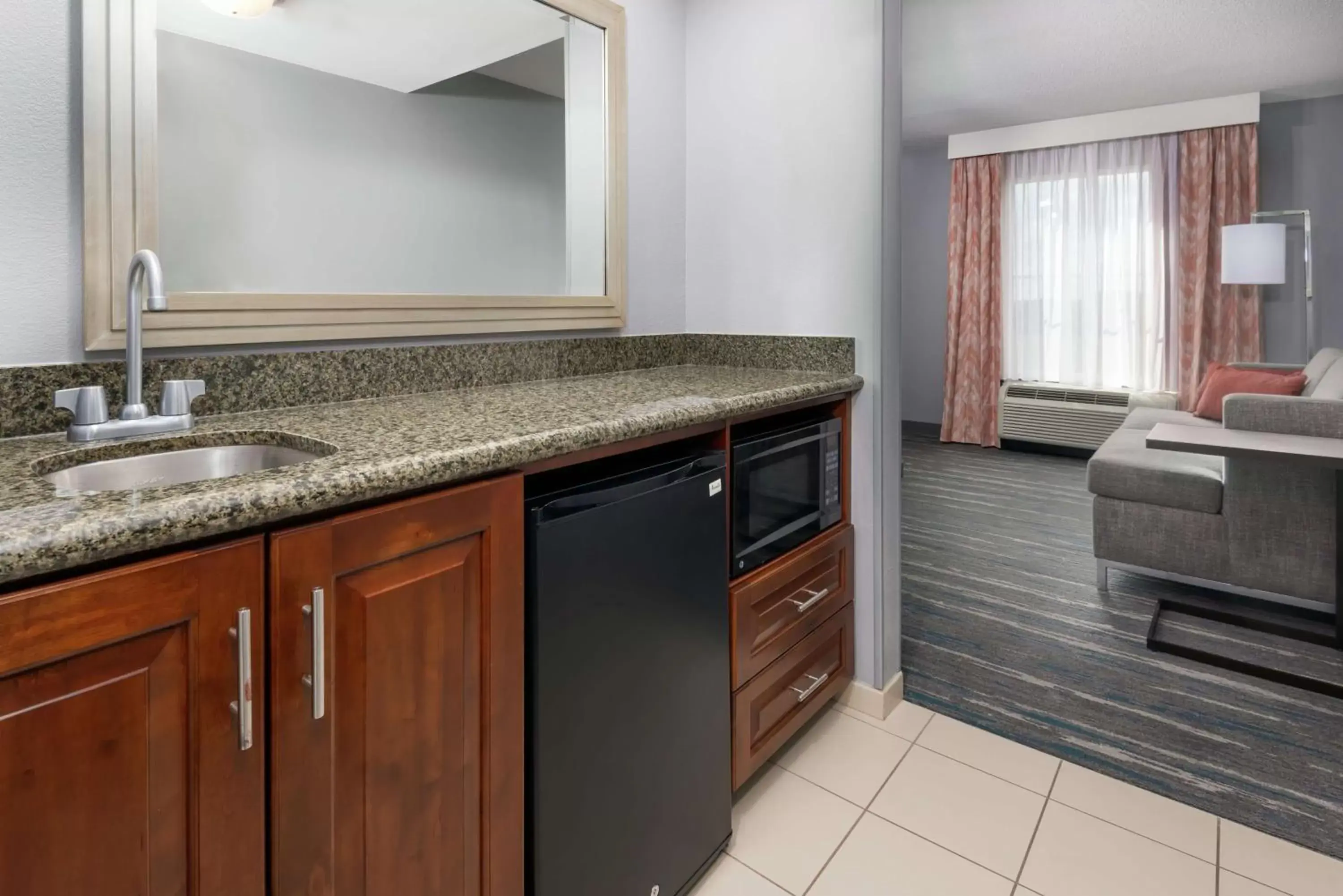 Living room, Kitchen/Kitchenette in Hampton Inn & Suites Orlando Airport at Gateway Village