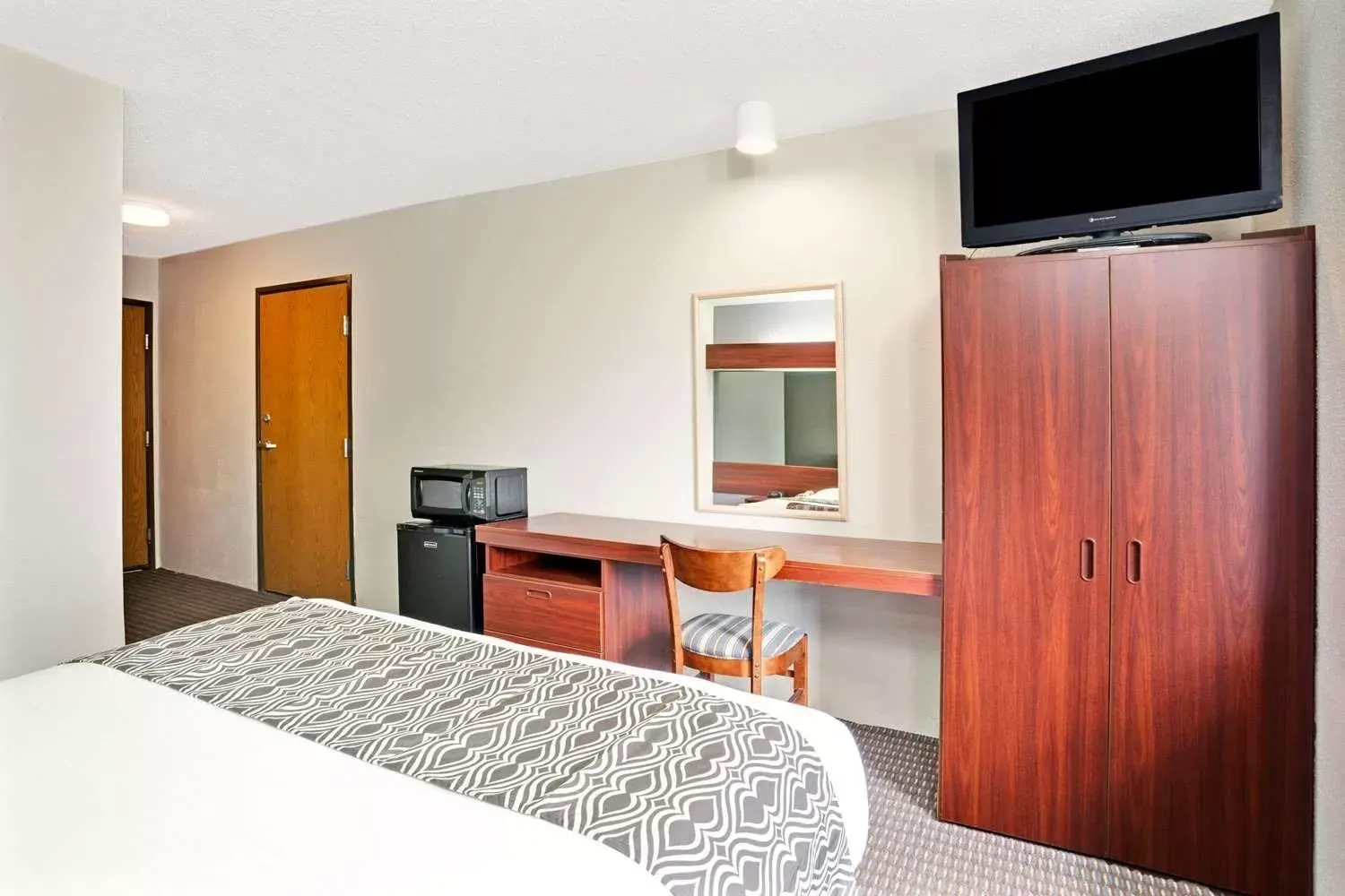 Bed, TV/Entertainment Center in Microtel Inn & Suites by Wyndham Detroit Roseville