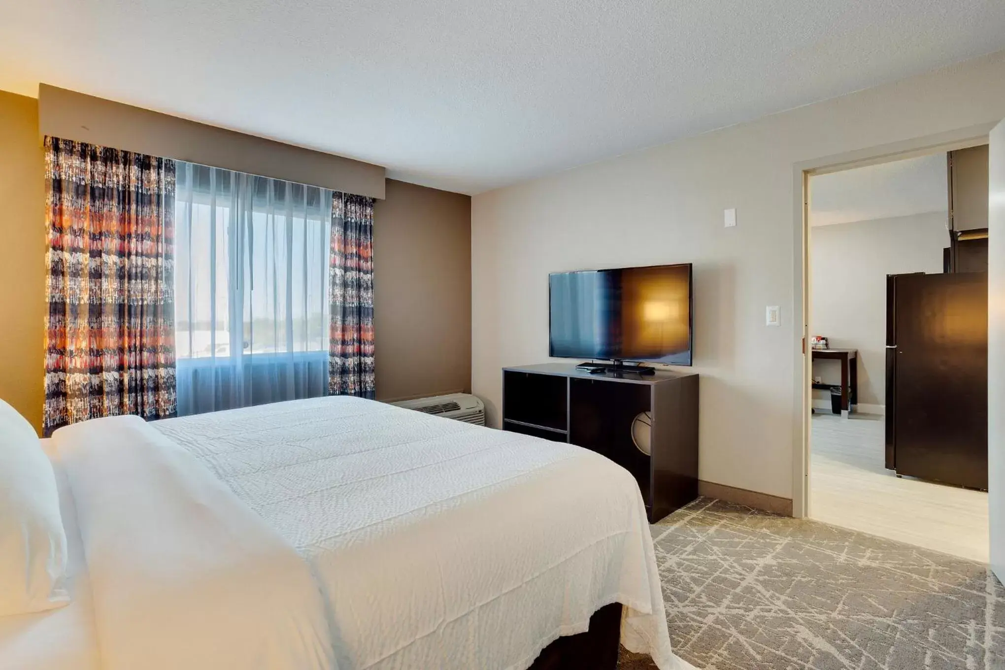 Bedroom, TV/Entertainment Center in Orangewood Inn & Suites Kansas City Airport
