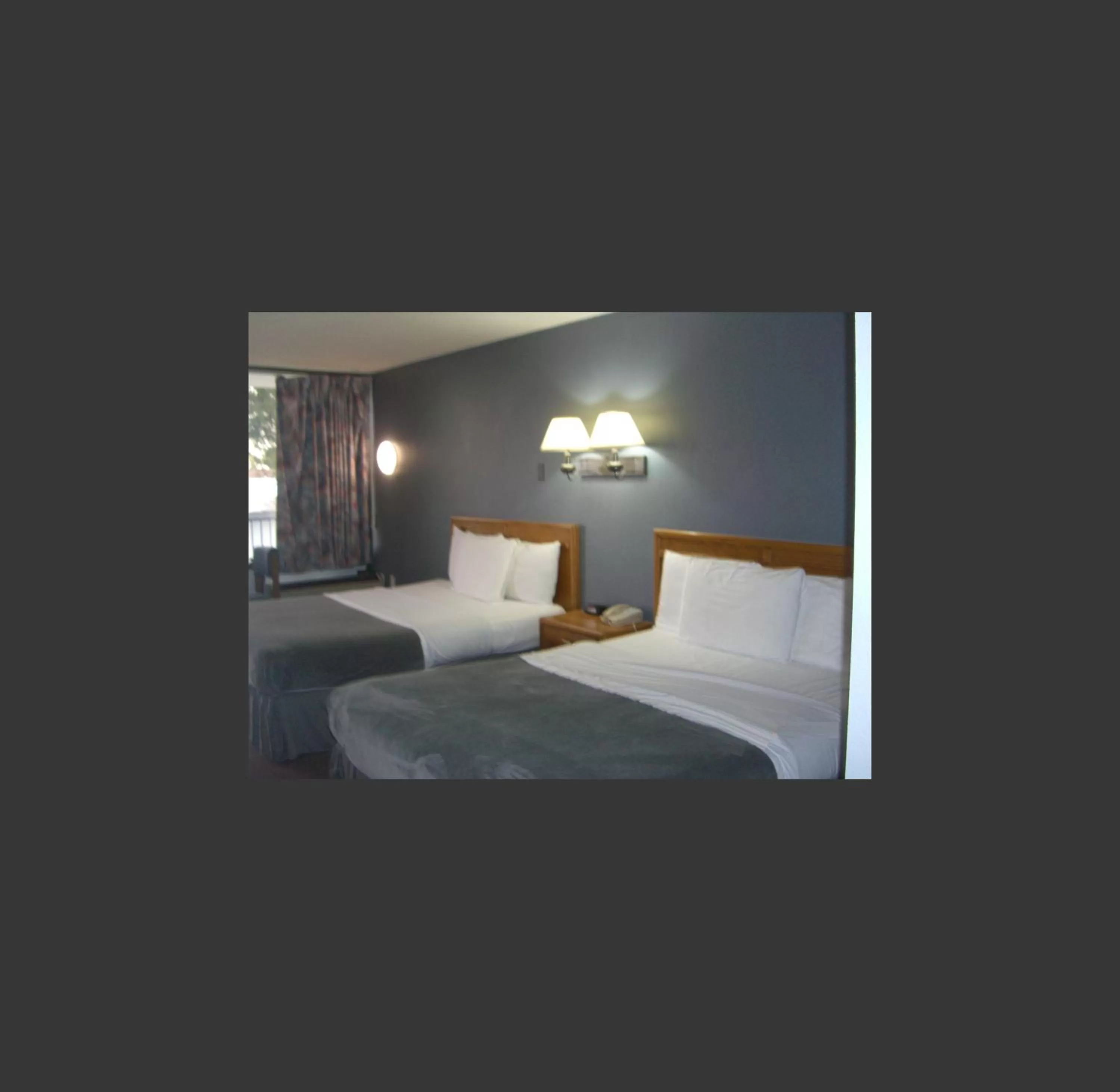 Bed in Quail's Nest Inn & Suites