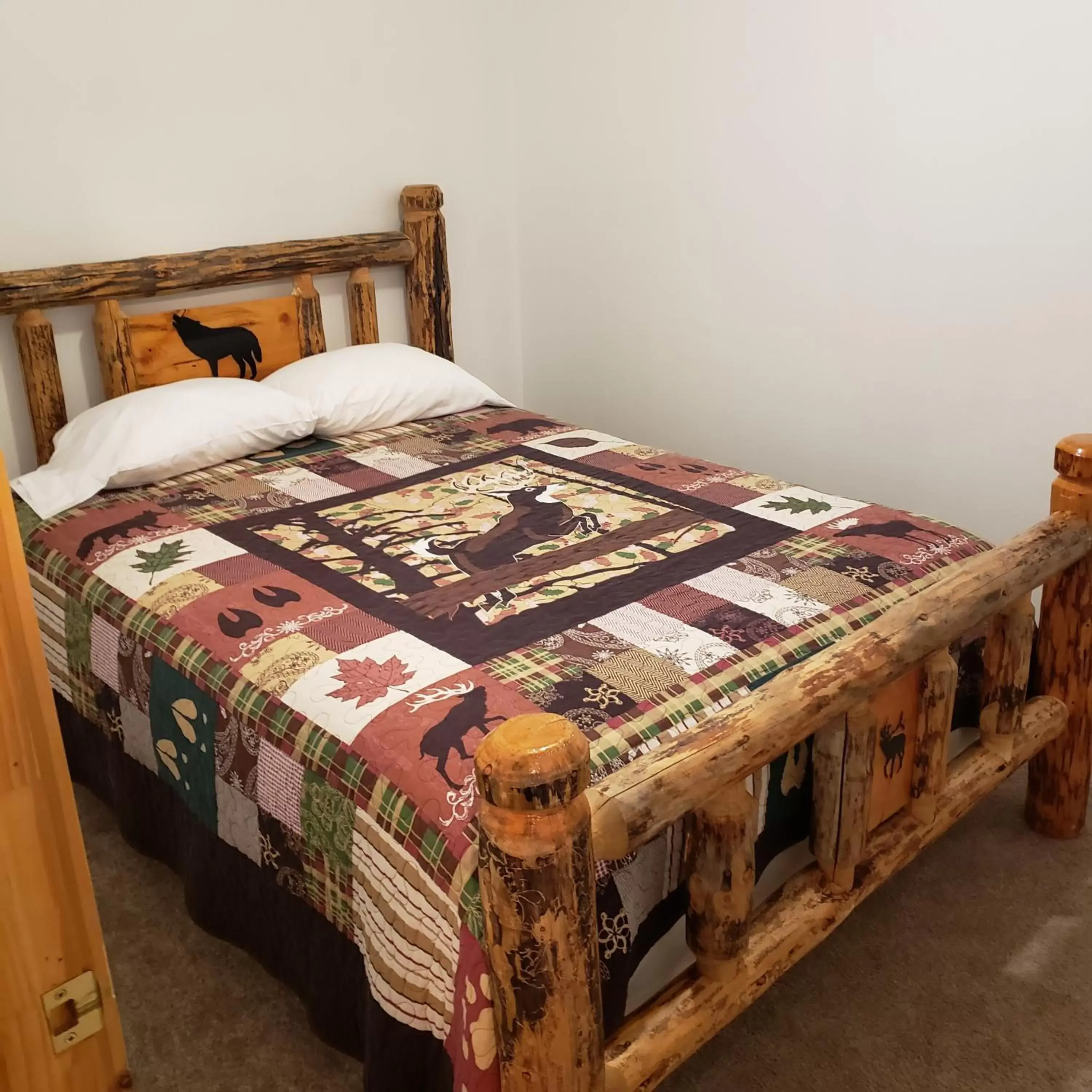 Bed in Wolf Den Log Cabin Motel and RV Park