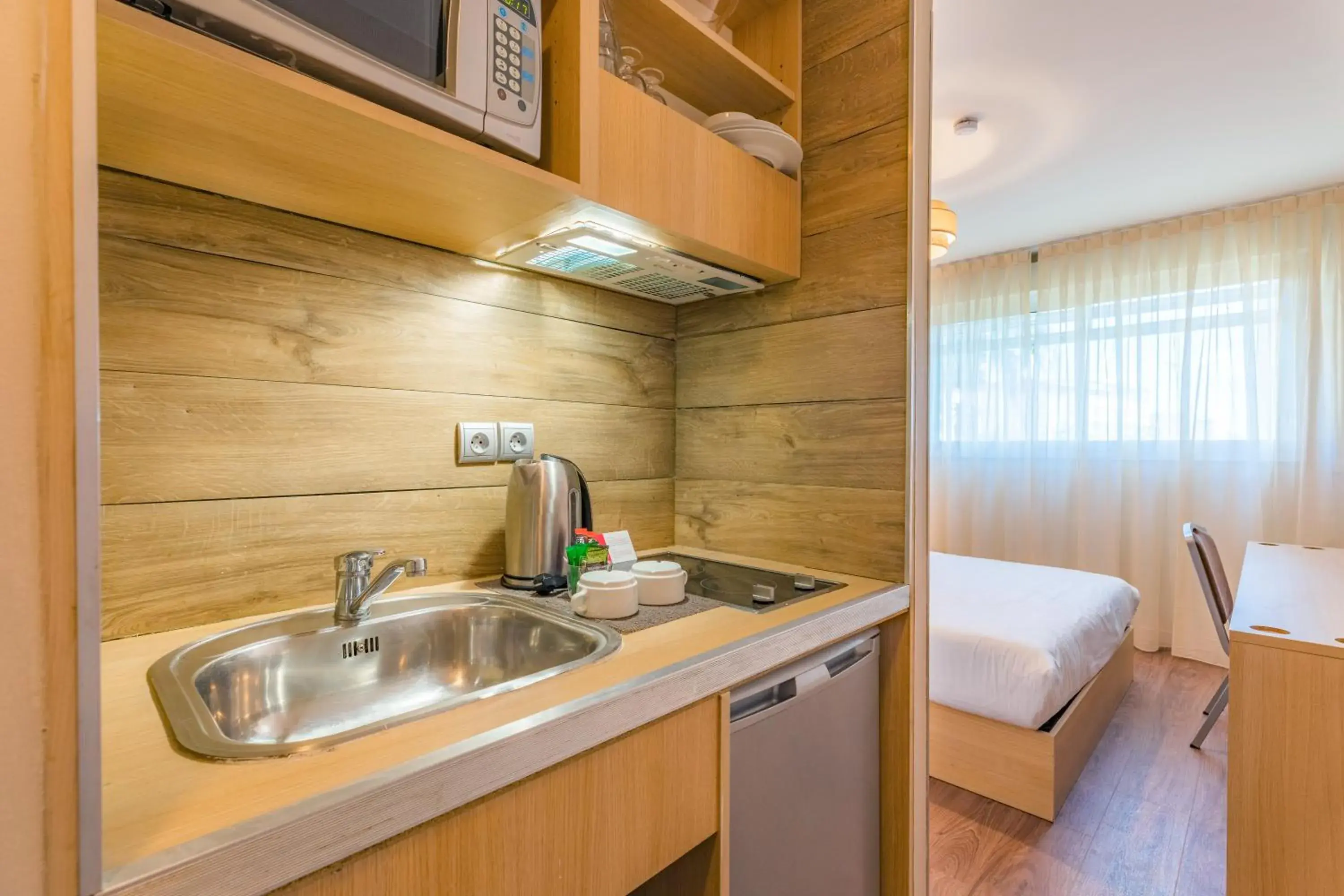 Bed, Kitchen/Kitchenette in Appart'City Confort Montpellier Ovalie I (Ex Park&Suites)