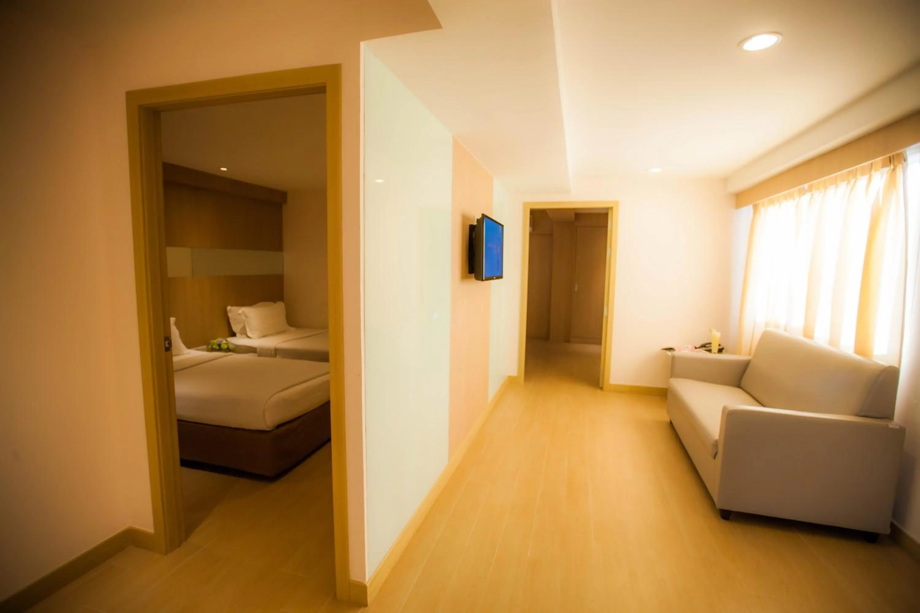 Living room, Bed in Golden City Rayong Hotel