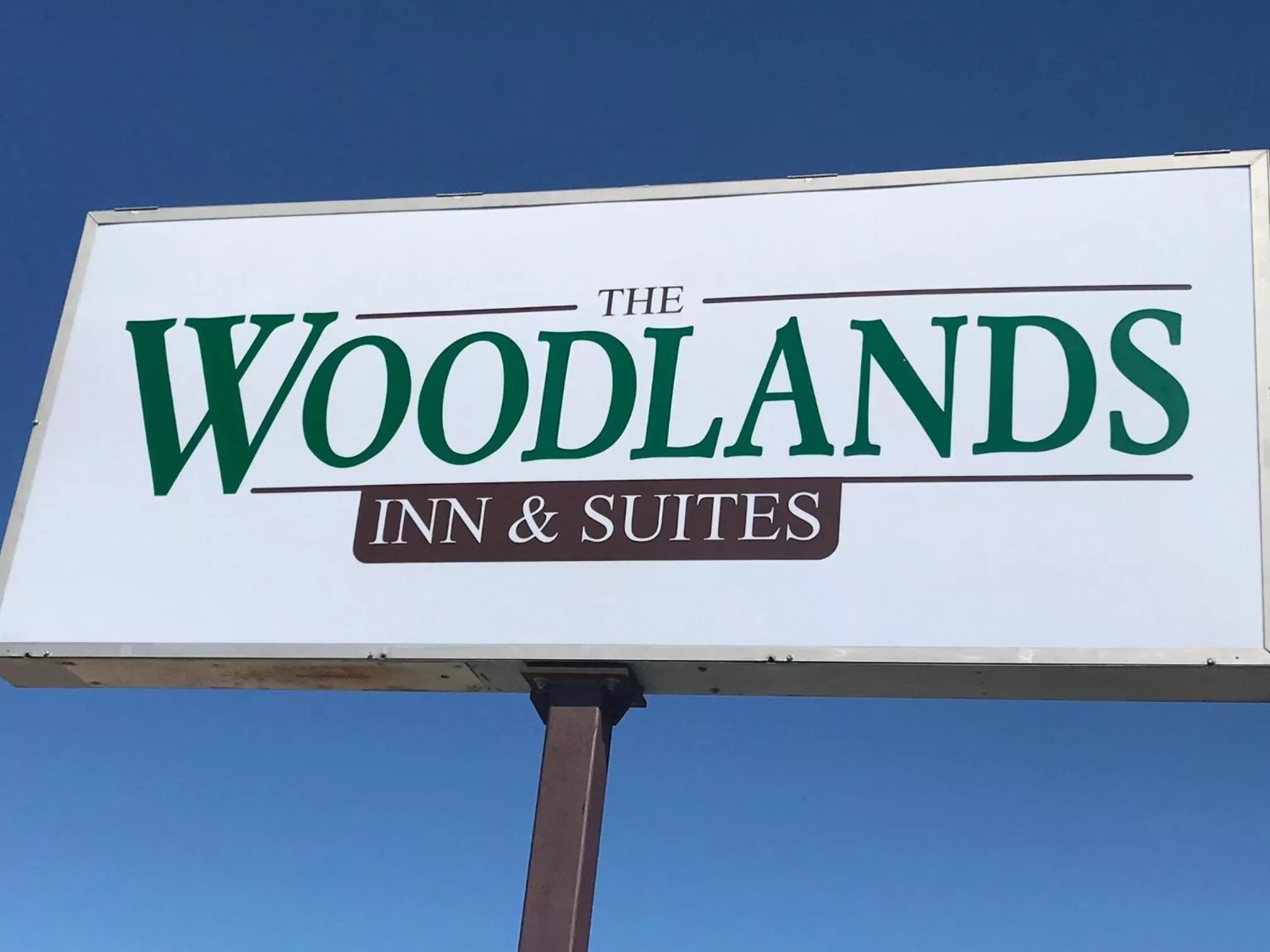 Property logo or sign in Woodland Inn & Suites
