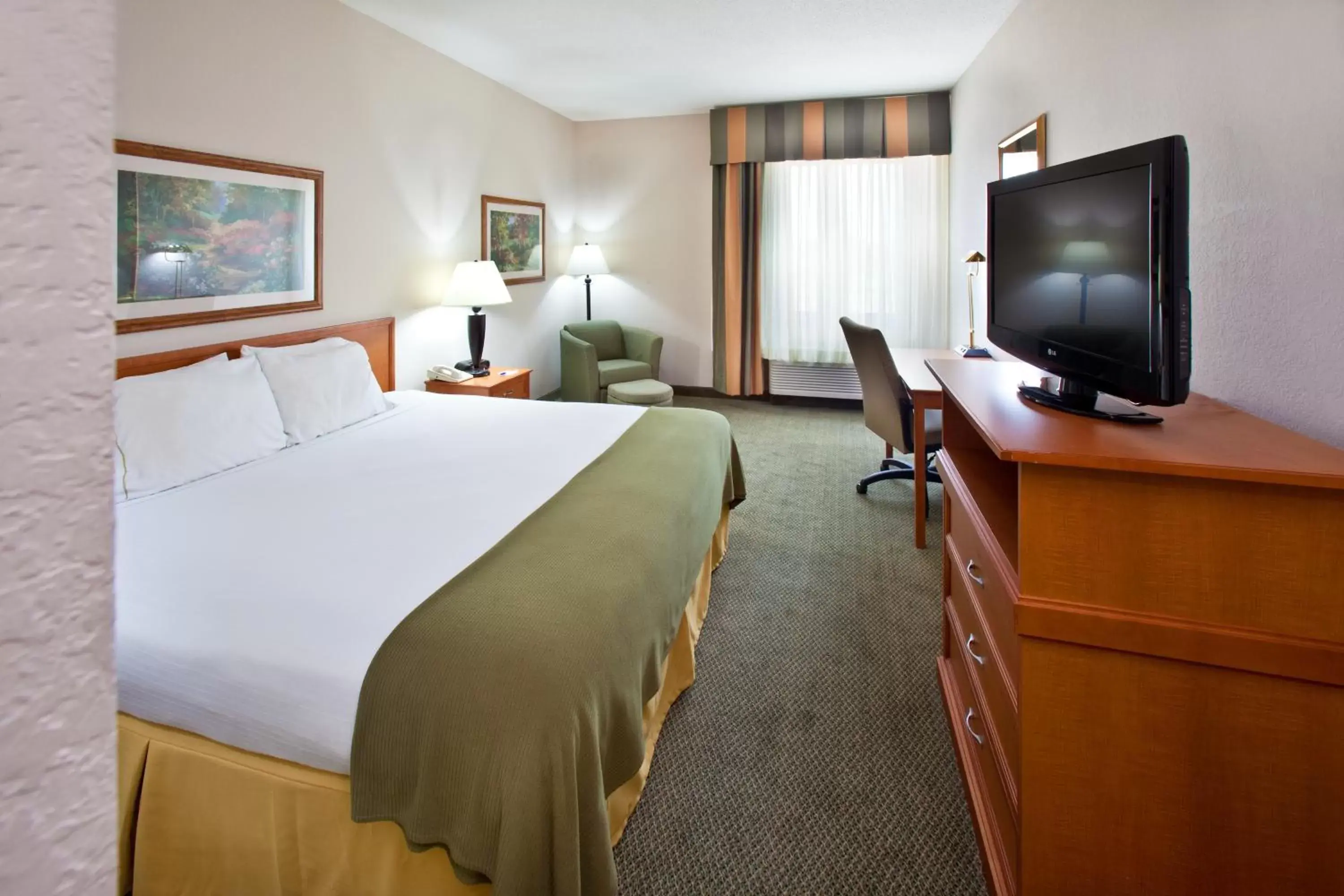 Bed, TV/Entertainment Center in GrandStay Hotel & Suites Pella