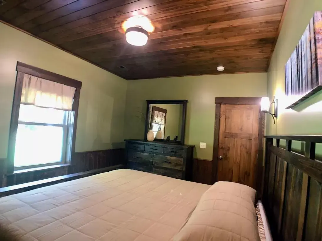 Bed in Sojourner's Lodge & Log Cabin Suites