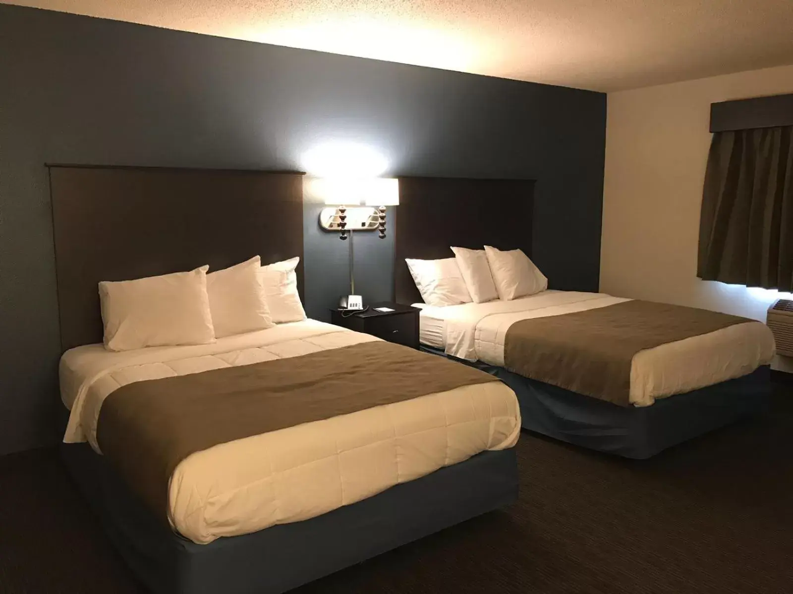 Bed in AmericInn by Wyndham Hotel and Suites Long Lake