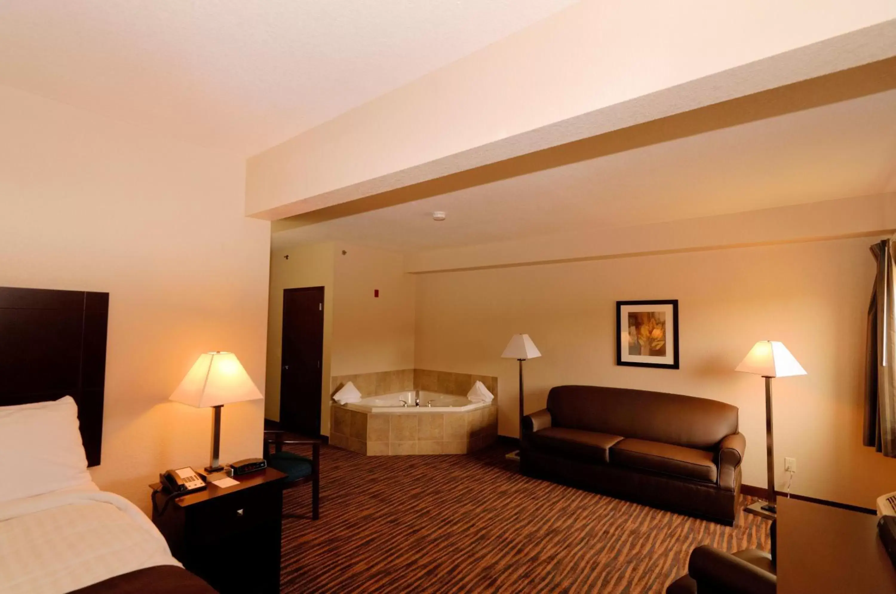 Bed, Seating Area in Cobblestone Inn & Suites - Denison | Oak Ridge