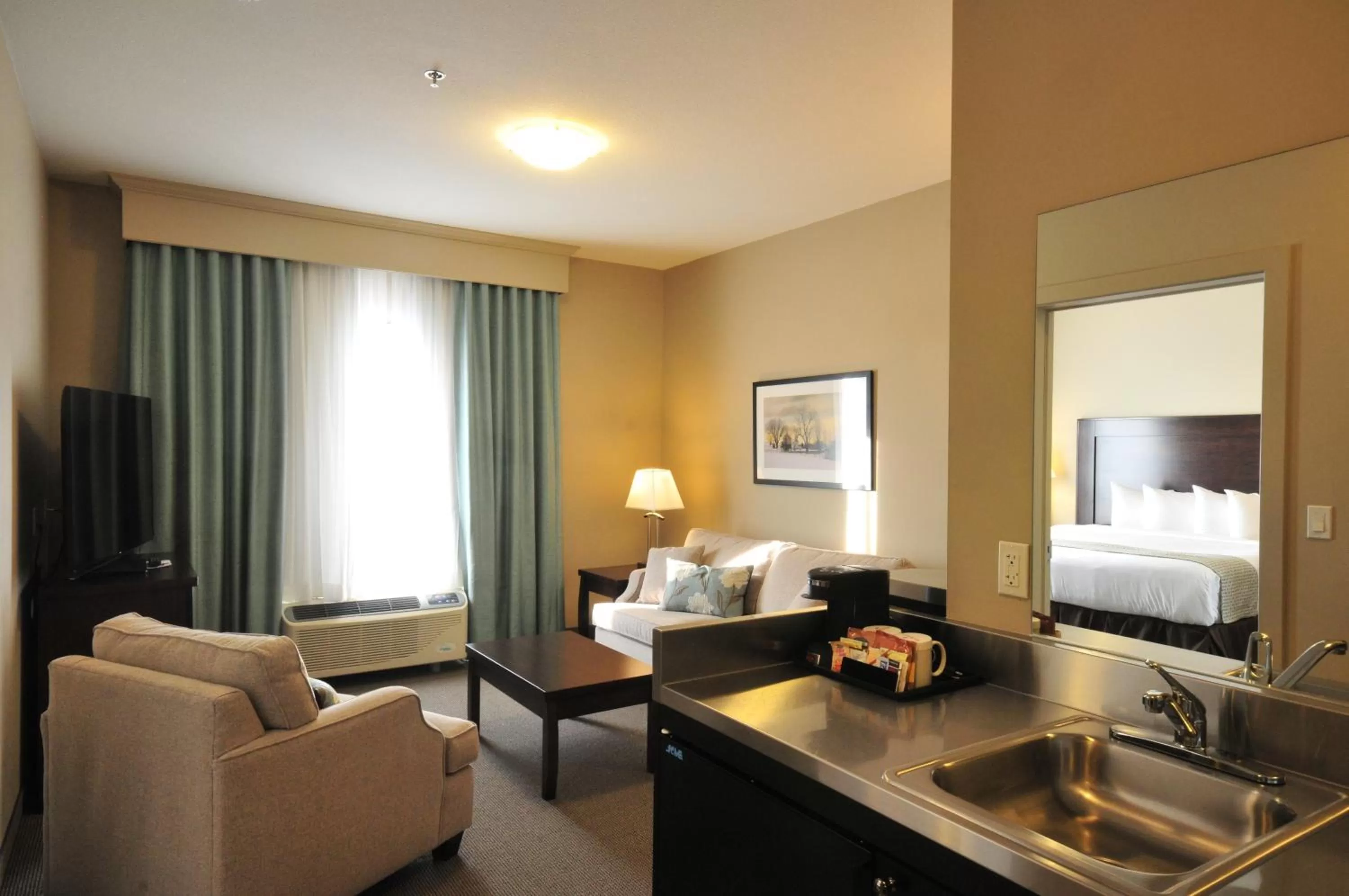 Seating area, Bed in Ramada by Wyndham Emerald Park/Regina East
