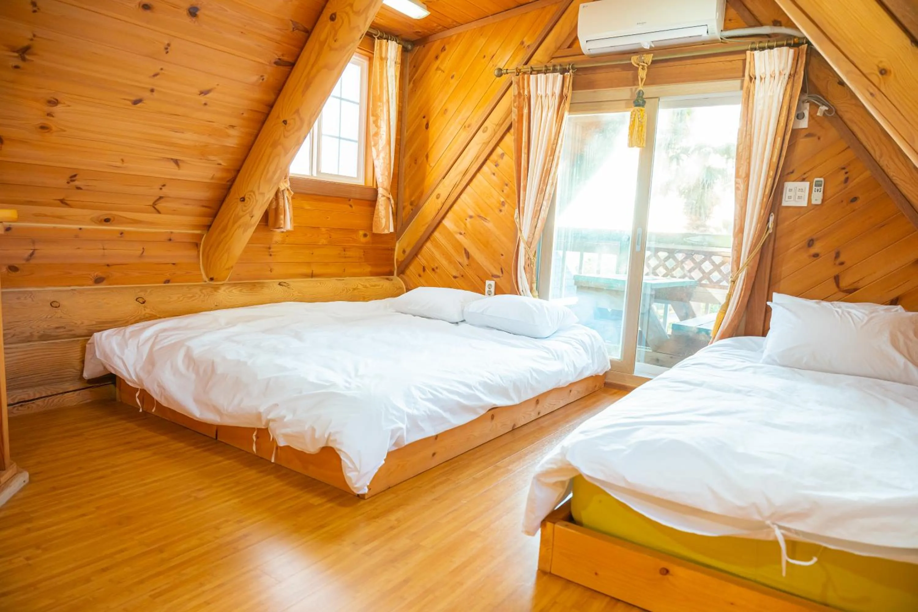 Bed in Jungmun Log Pension & Resort