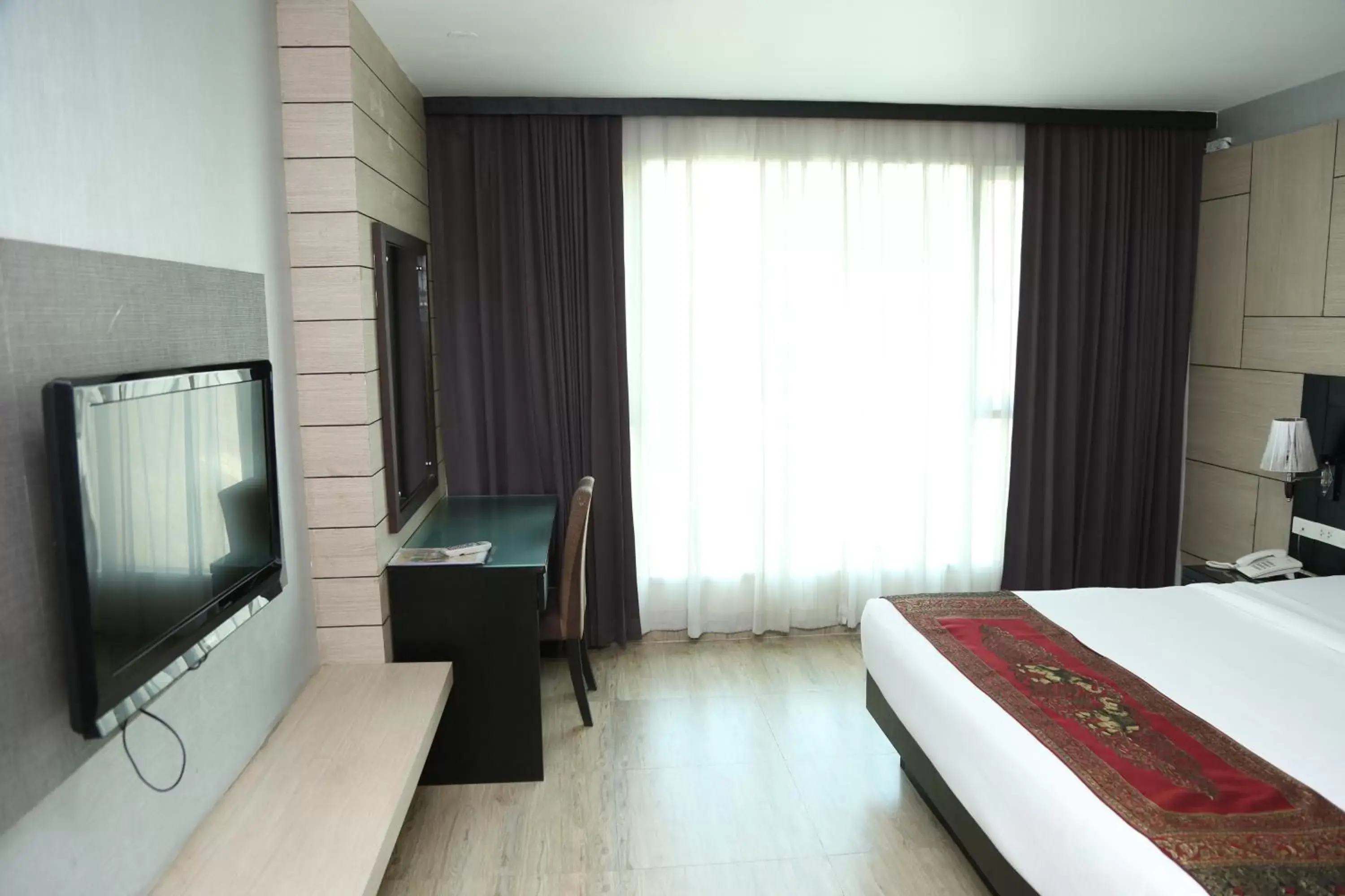 Bed, TV/Entertainment Center in Boss Suites Nana Hotel