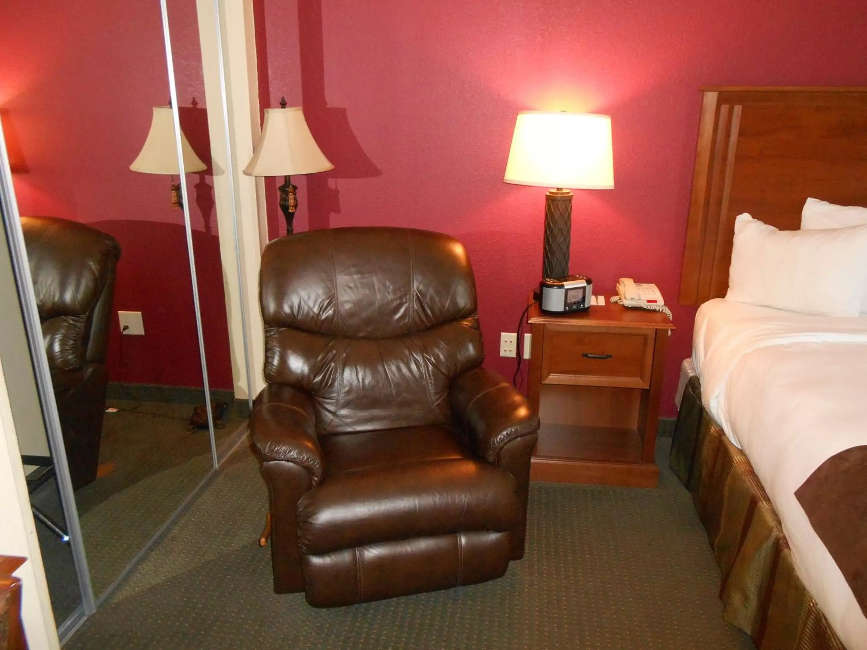 Bed, Seating Area in AmericInn by Wyndham McAlester