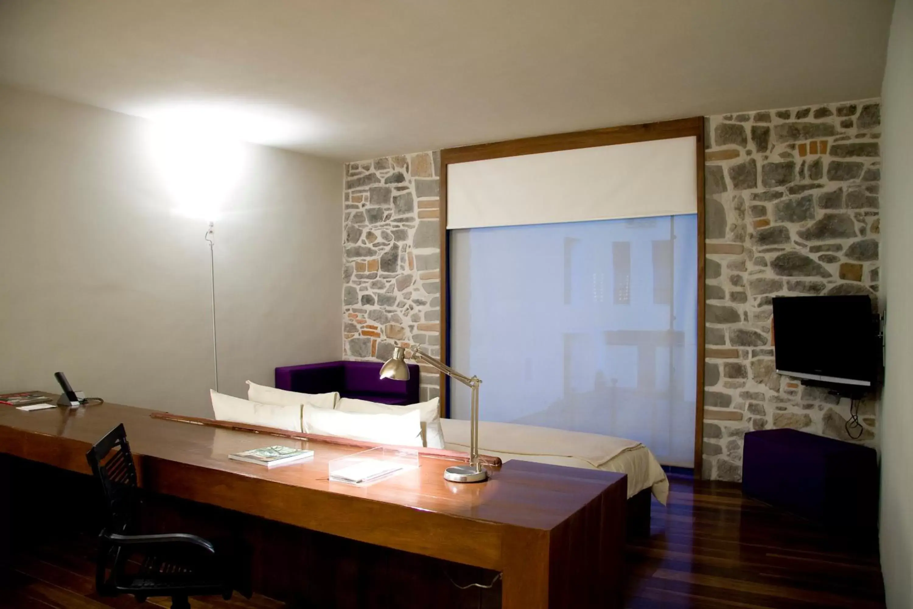 Bedroom, TV/Entertainment Center in La Purificadora, Puebla, a Member of Design Hotels