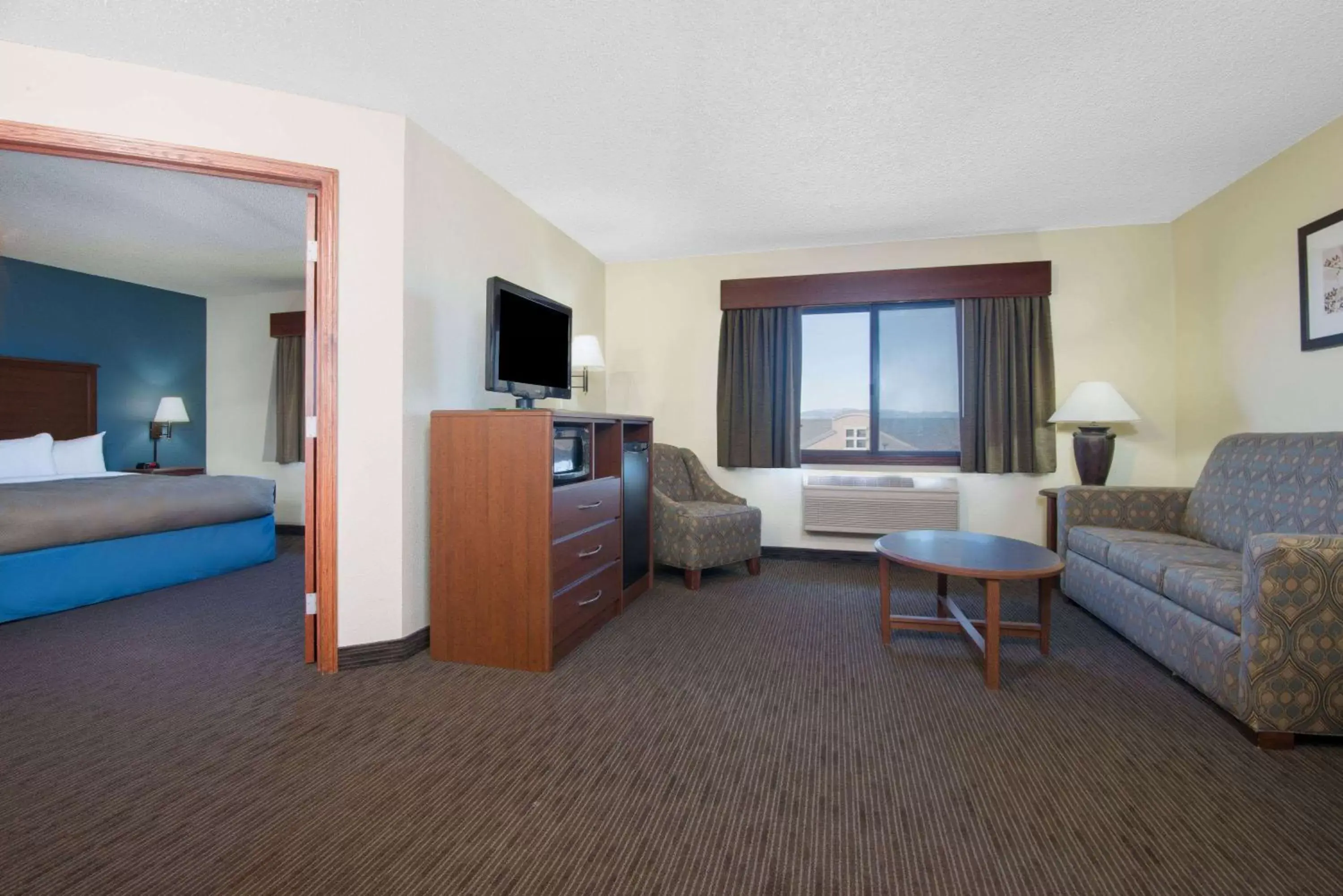 Bed, Seating Area in AmericInn by Wyndham Windsor Ft. Collins