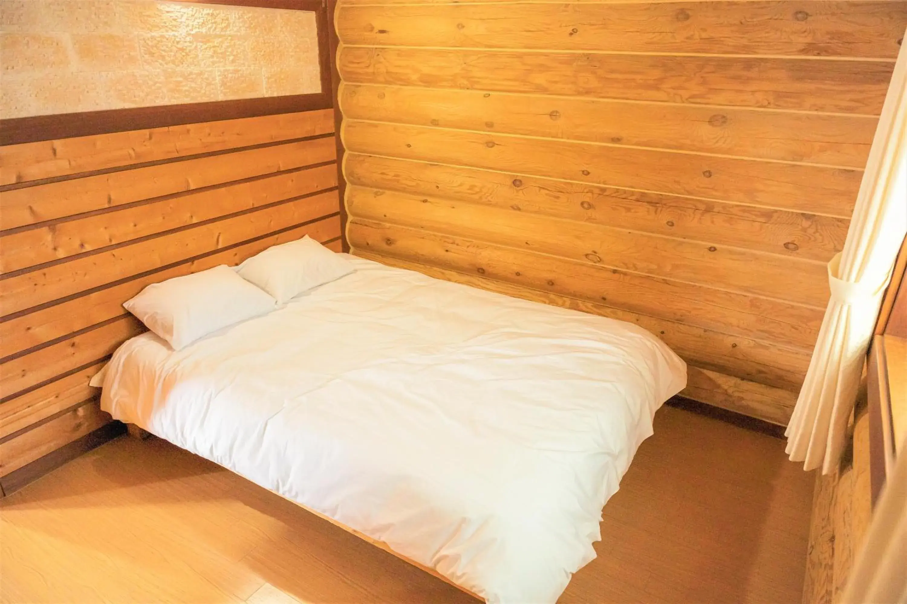 Bed in Jungmun Log Pension & Resort