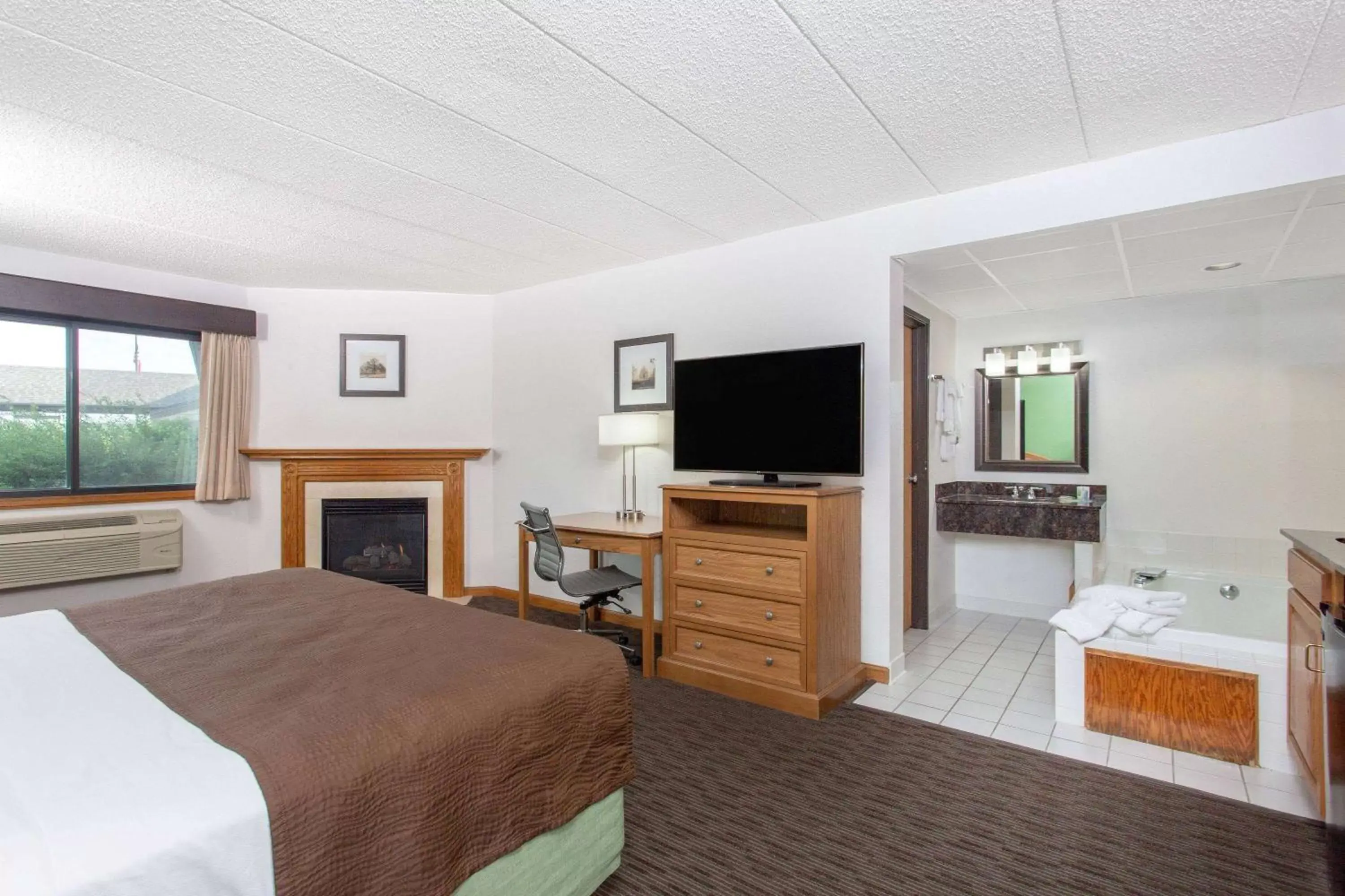 Bed, TV/Entertainment Center in AmericInn by Wyndham Eau Claire