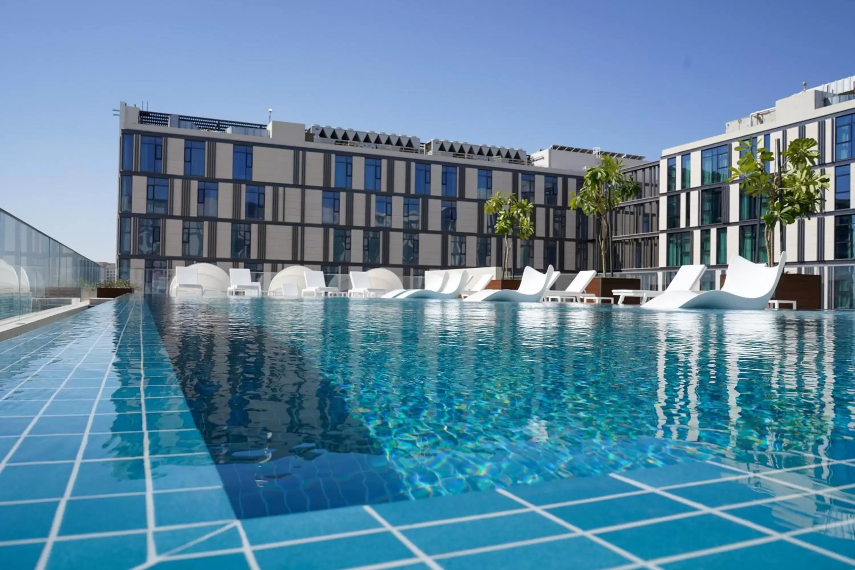 Property building, Swimming Pool in Staybridge Suites Dubai Al-Maktoum Airport, an IHG Hotel