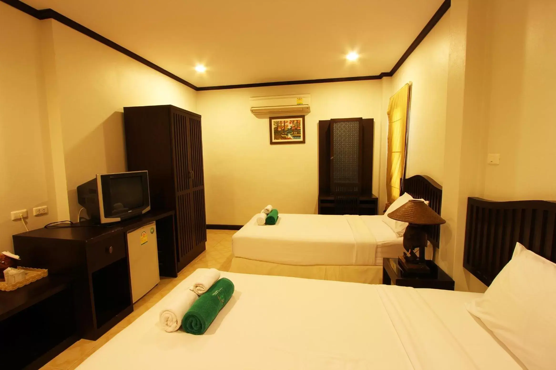 Bed, TV/Entertainment Center in The Green Beach Resort