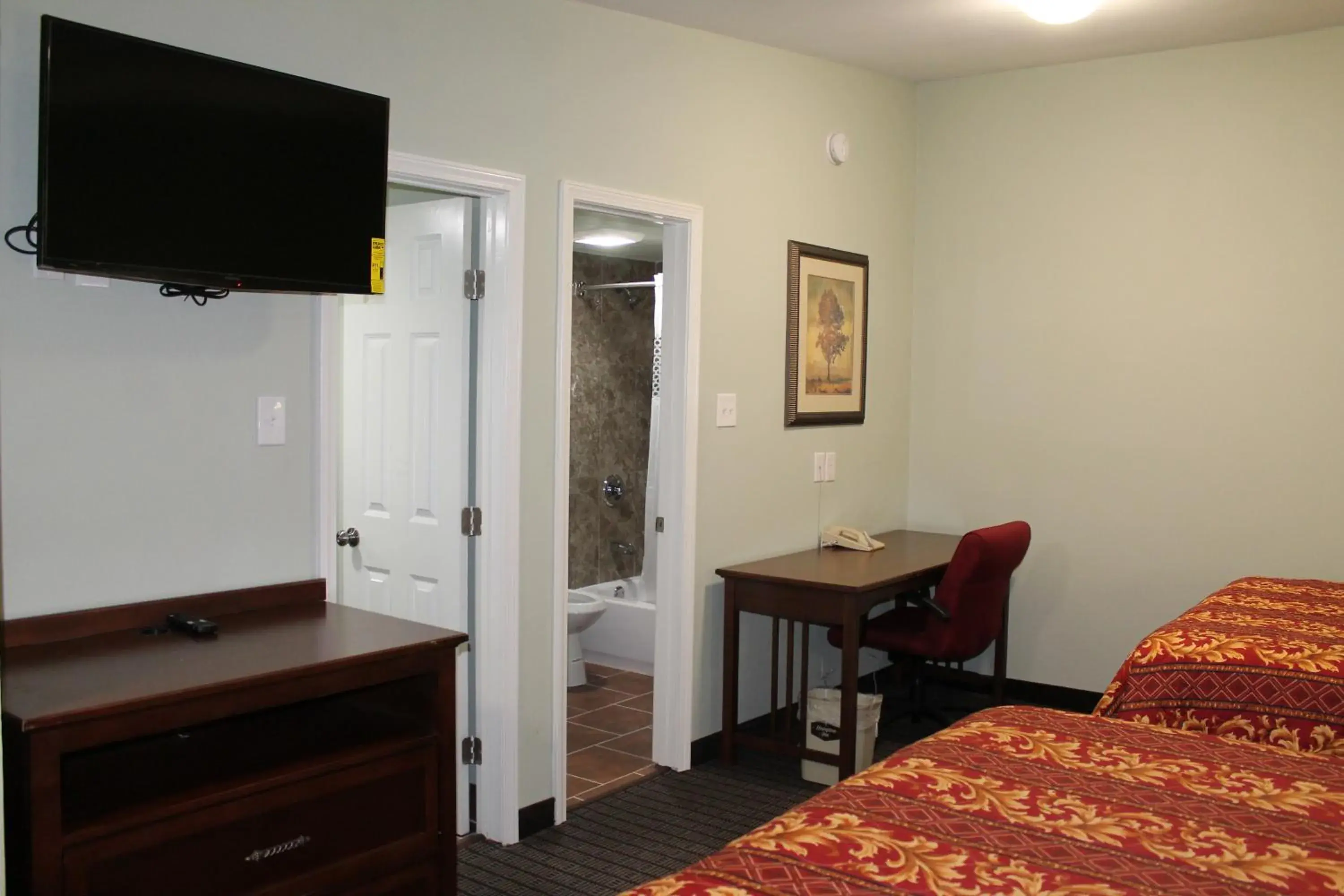 Toilet, TV/Entertainment Center in American Inn & Suites