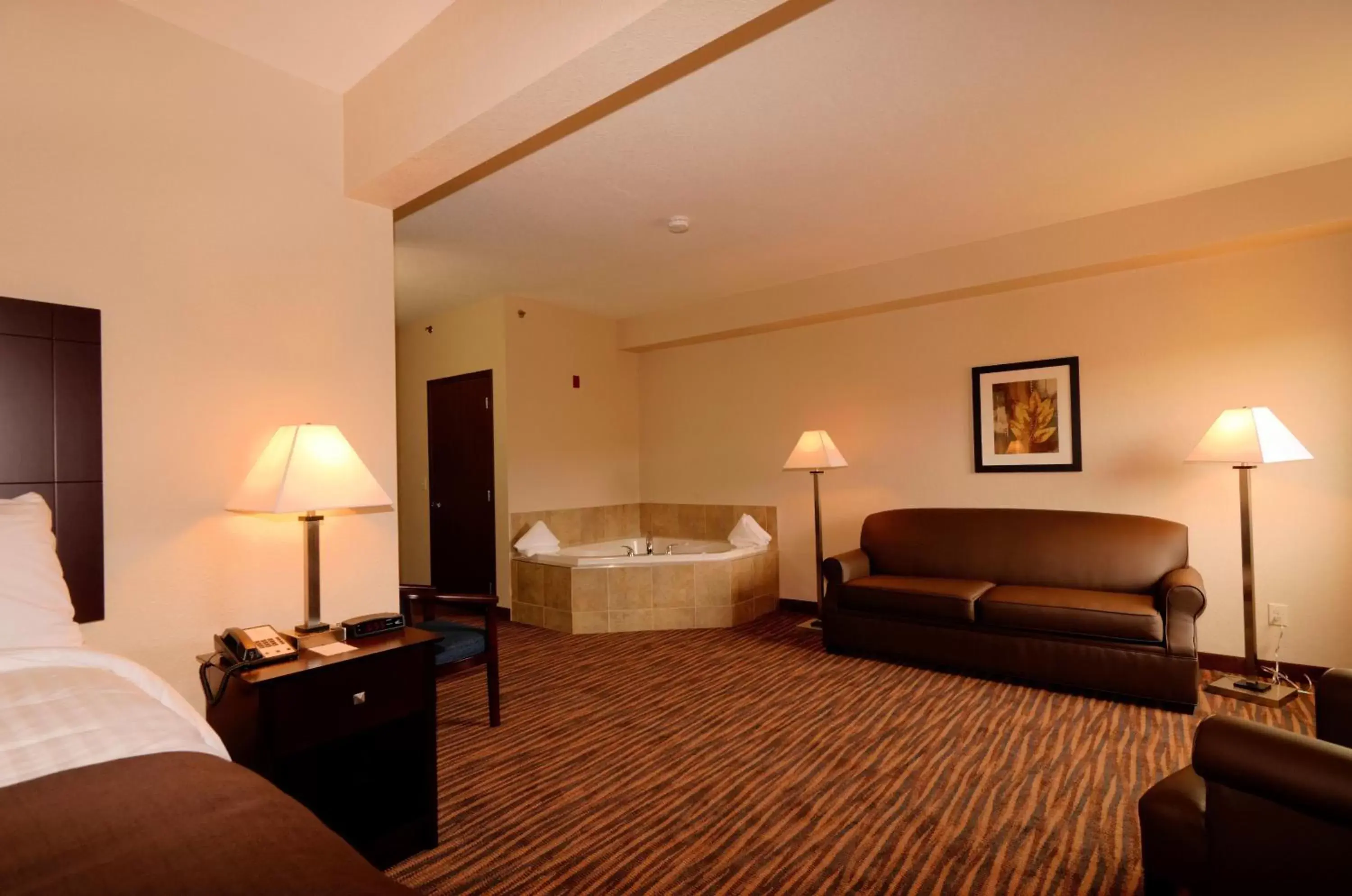 Bed, Seating Area in Cobblestone Inn & Suites - Denison | Oak Ridge