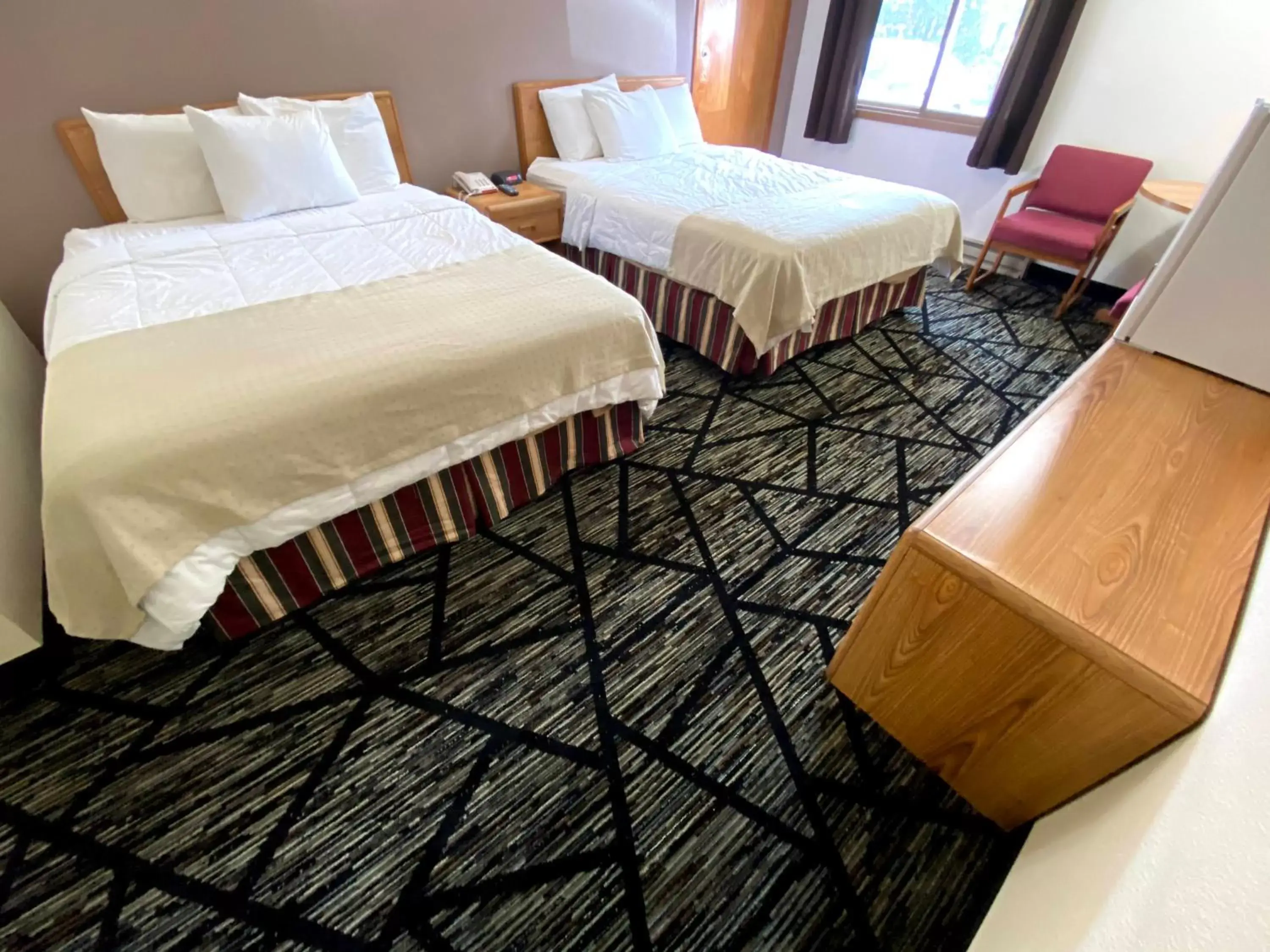 Bed in Woodland Inn & Suites