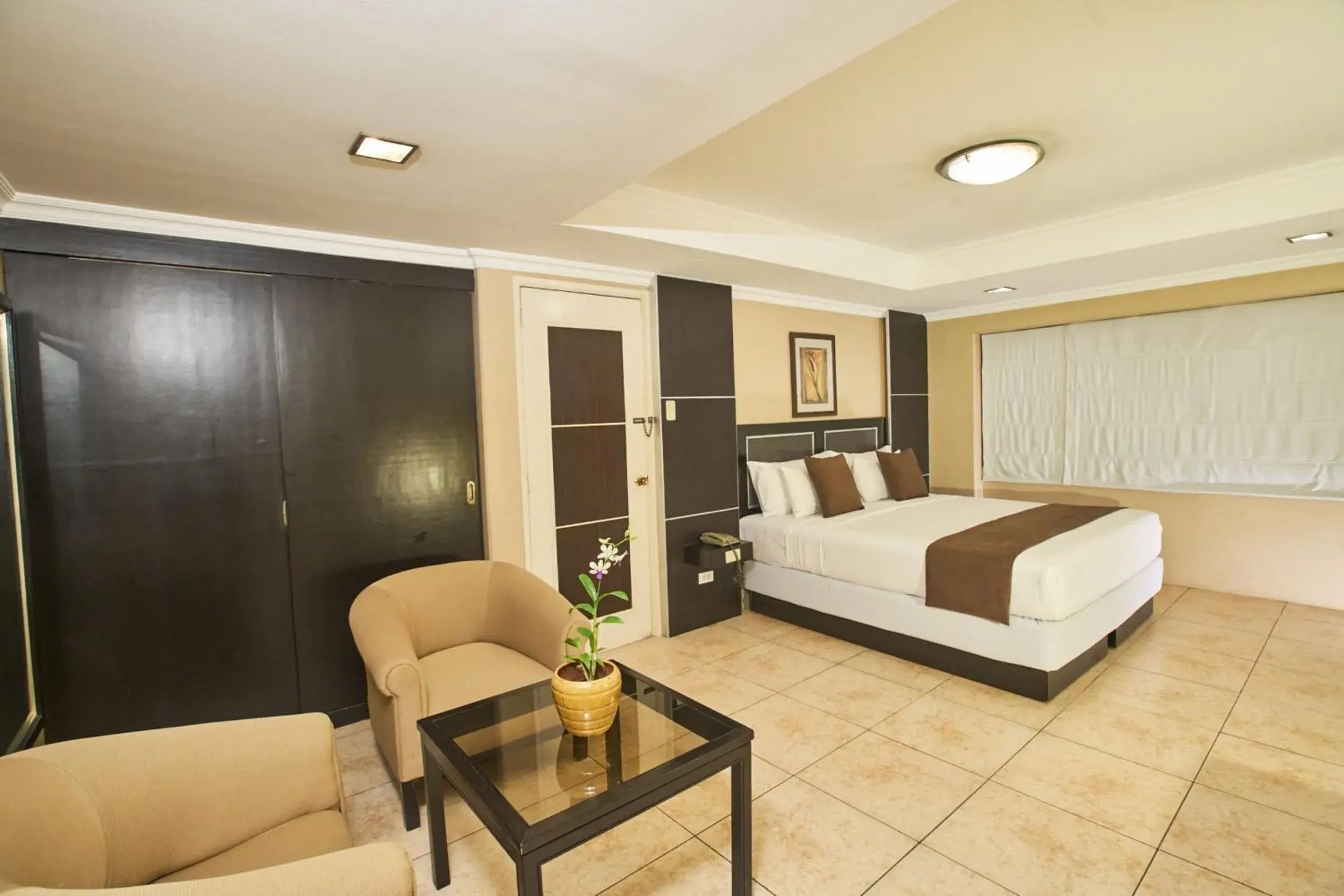 Bed, Seating Area in Orchid Garden Suites