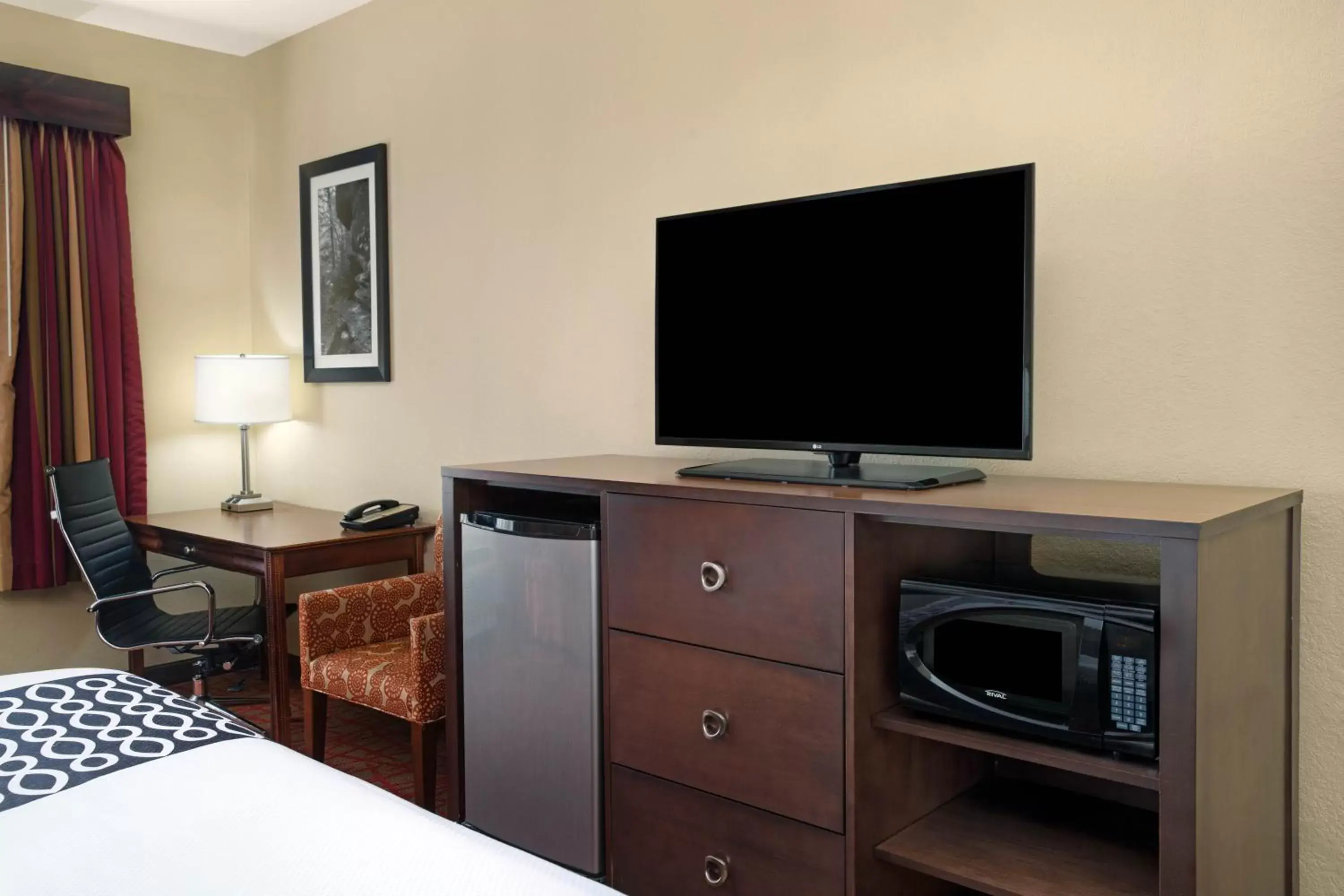 Communal lounge/ TV room, TV/Entertainment Center in La Quinta by Wyndham Oxford - Anniston
