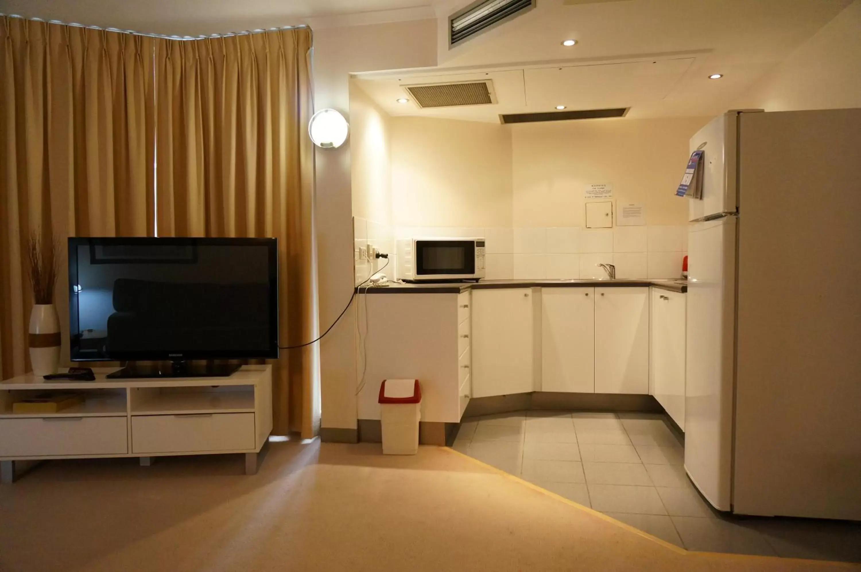 Kitchen or kitchenette, TV/Entertainment Center in Abbey On Roma Hotel & Apartments
