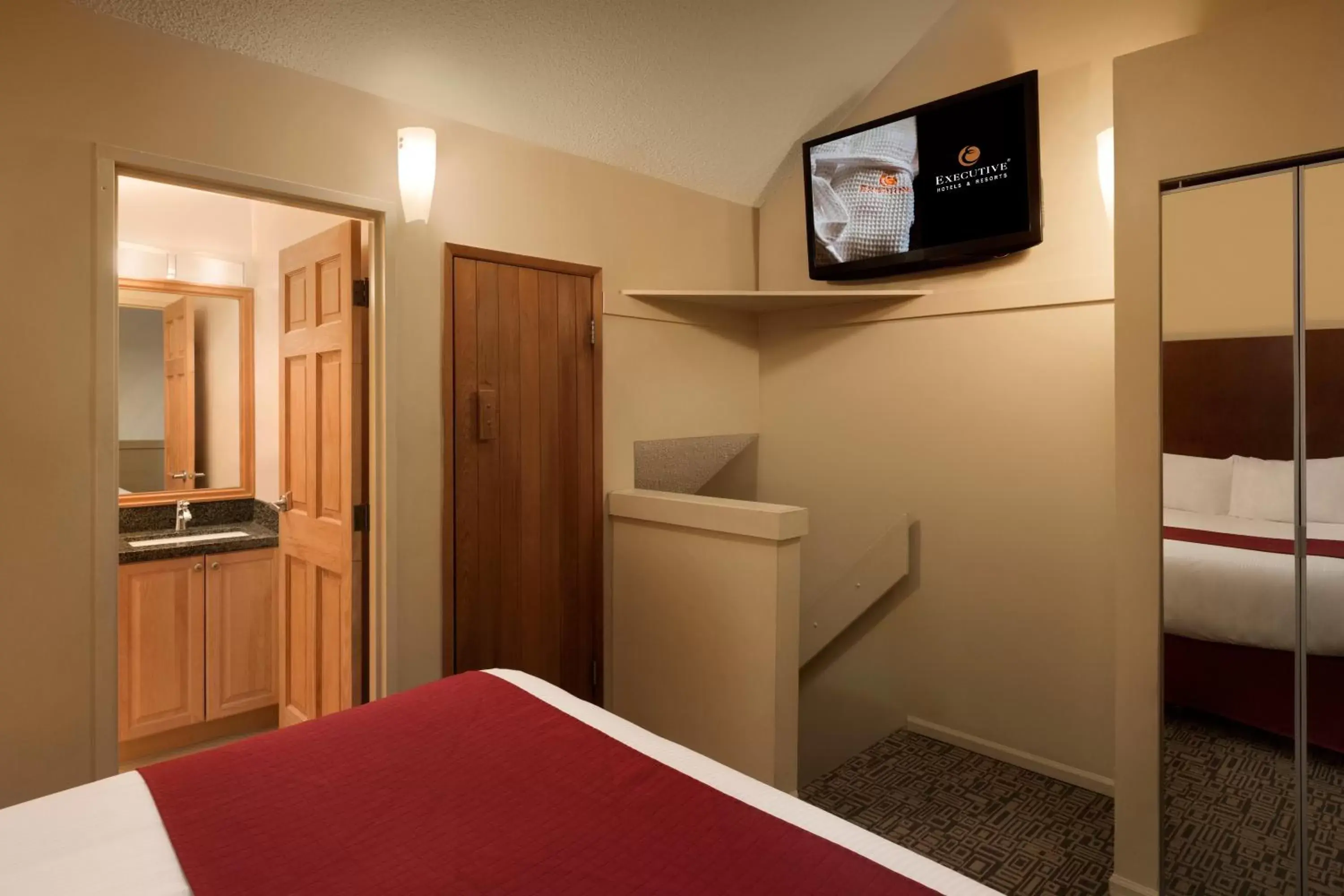 Bed, TV/Entertainment Center in Mountain Side Hotel Whistler by Executive