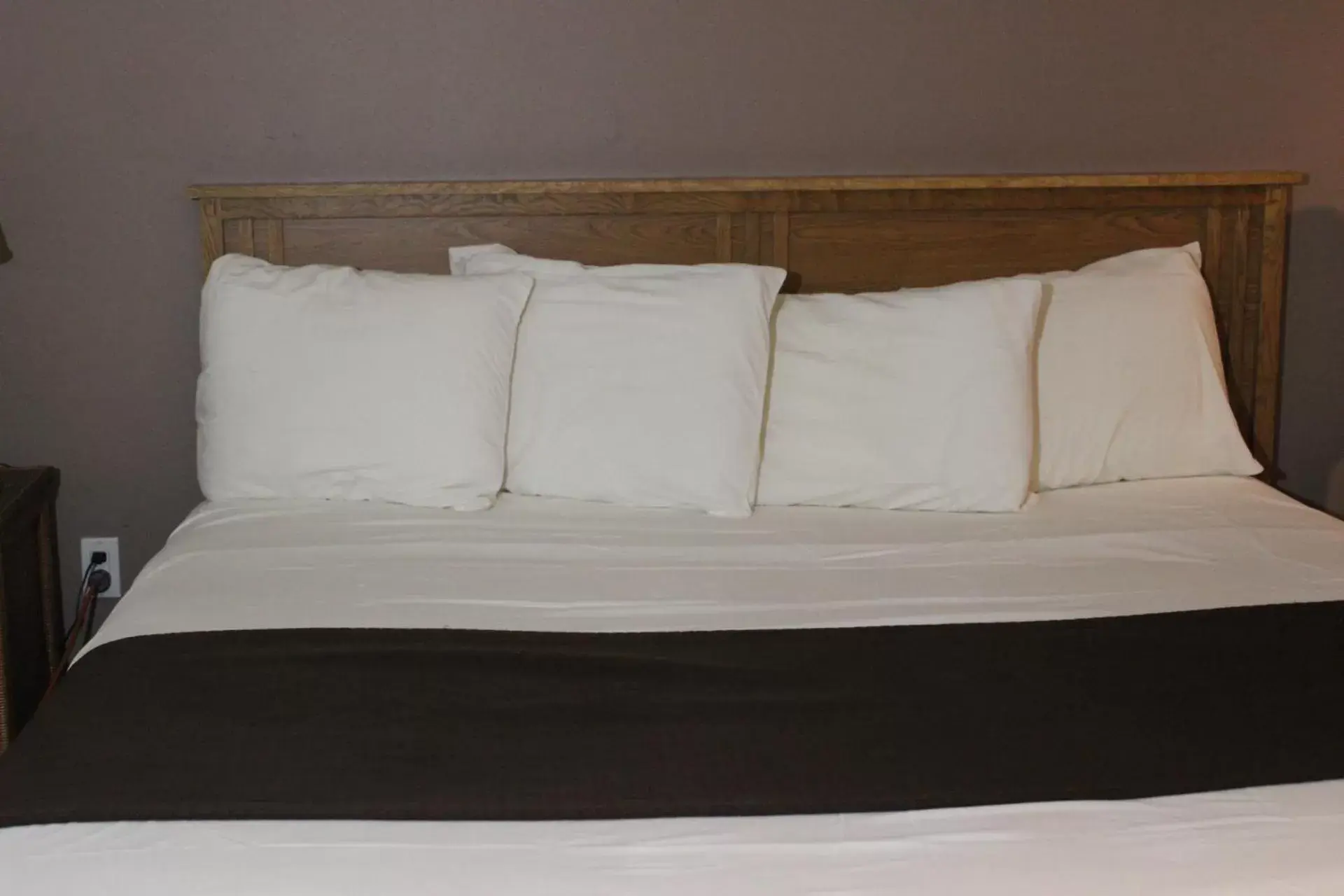 Bed in Woodland Inn & Suites
