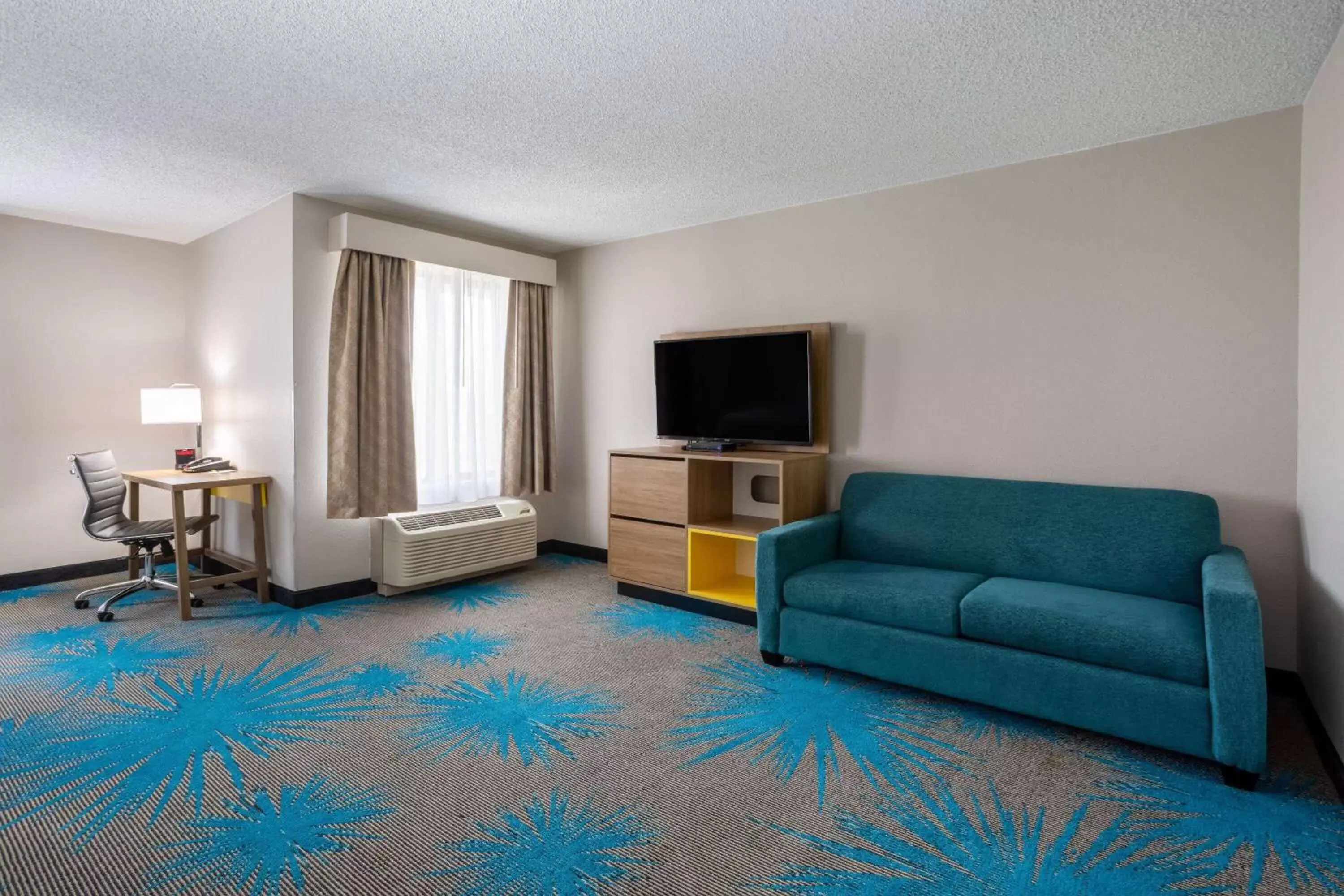 Bed, Seating Area in Days Inn & Suites by Wyndham Denver International Airport