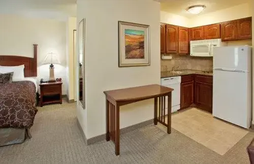 Bed, Kitchen/Kitchenette in Staybridge Suites - Kansas City-Independence, an IHG Hotel