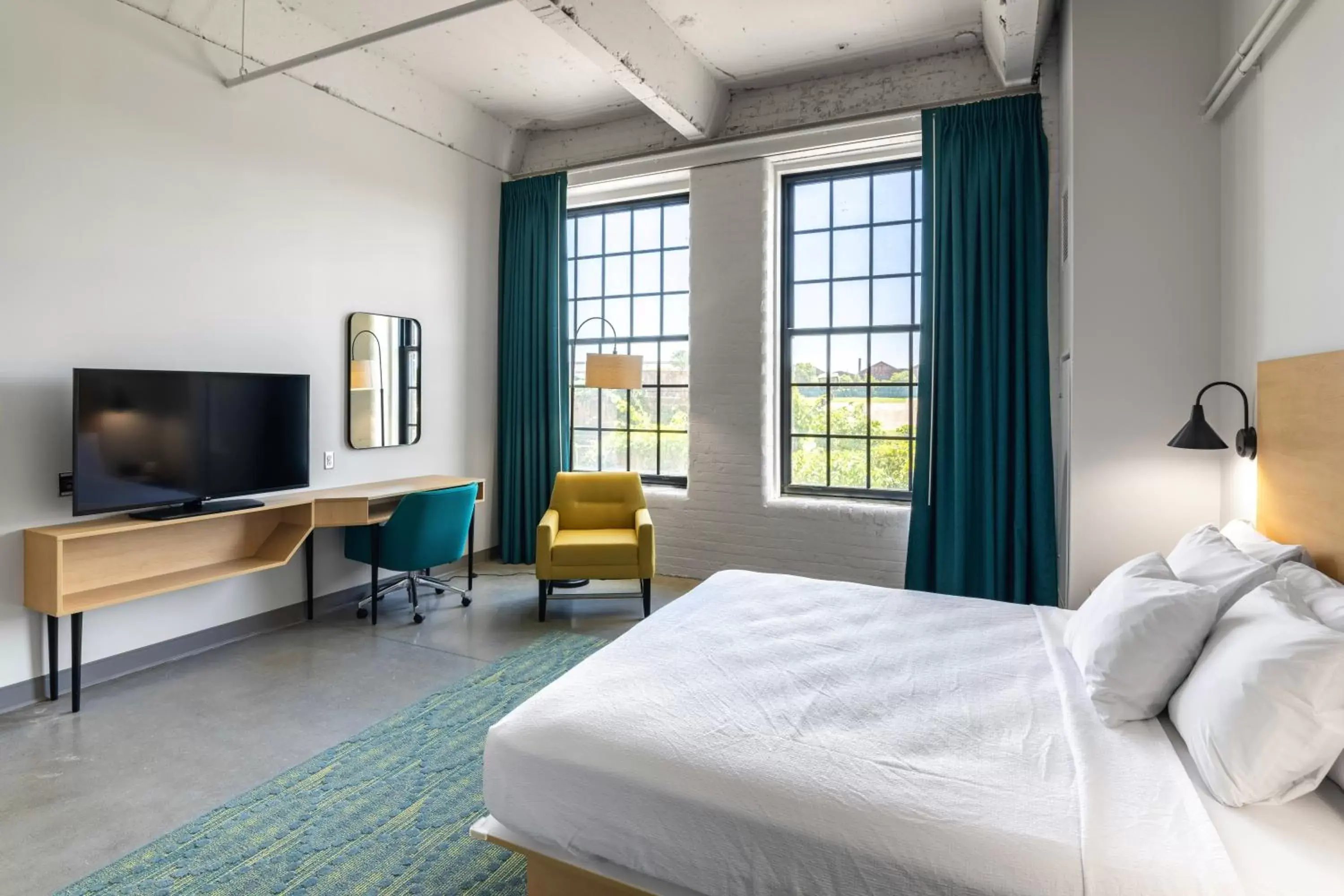 Bed, TV/Entertainment Center in The Warehouse Hotel at Champion Mill
