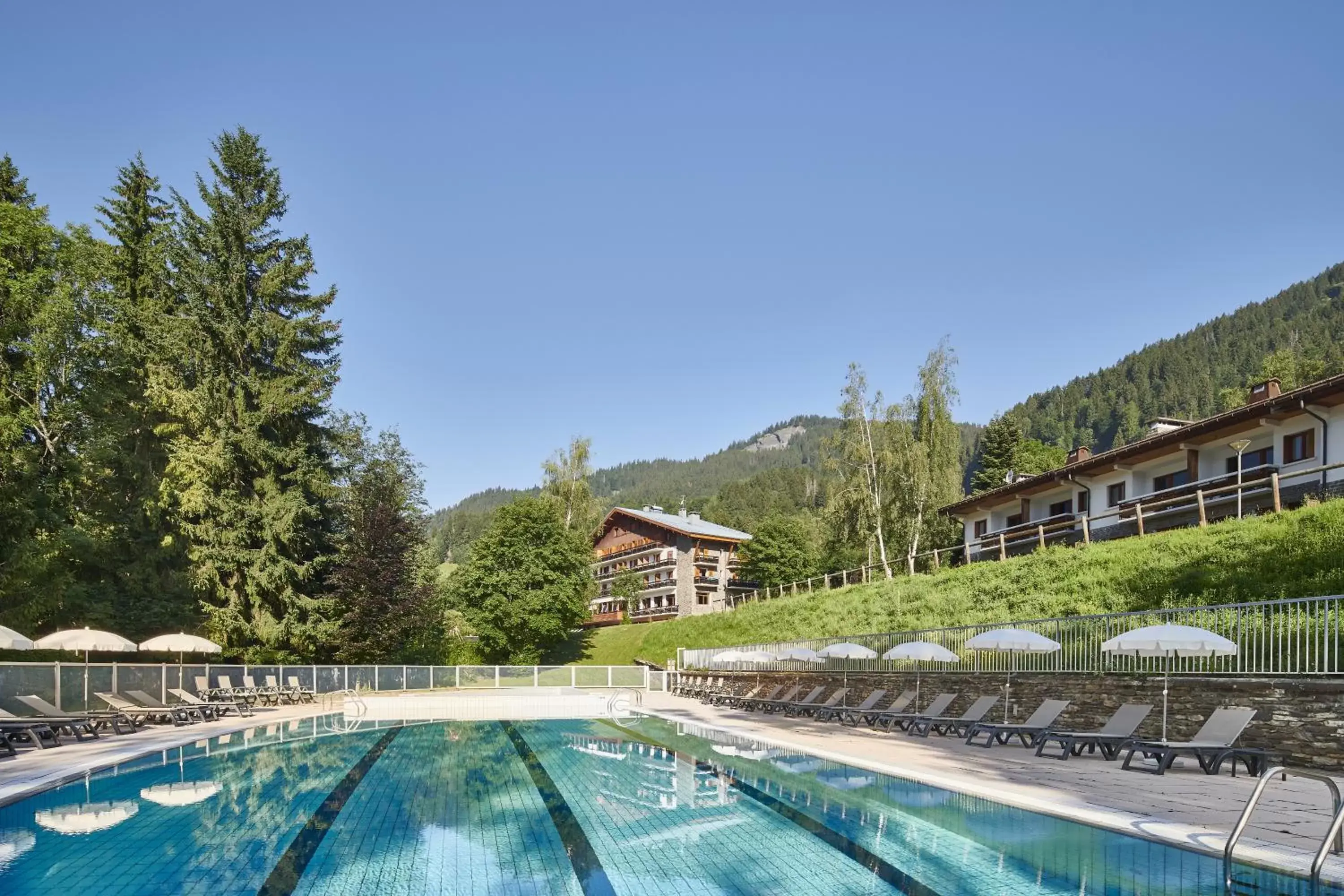 Property building, Swimming Pool in Hôtel Vacances Bleues Les Chalets du Prariand