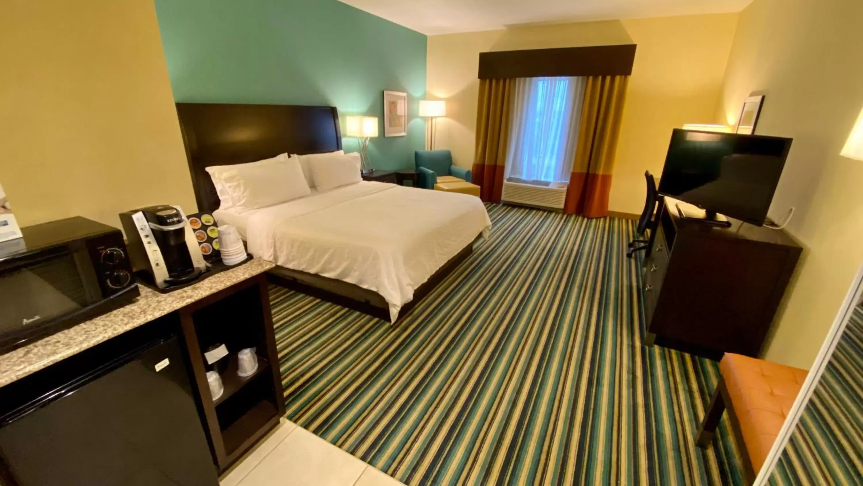 Photo of the whole room, TV/Entertainment Center in Holiday Inn Express Hotel & Suites Orlando East-UCF Area, an IHG Hotel