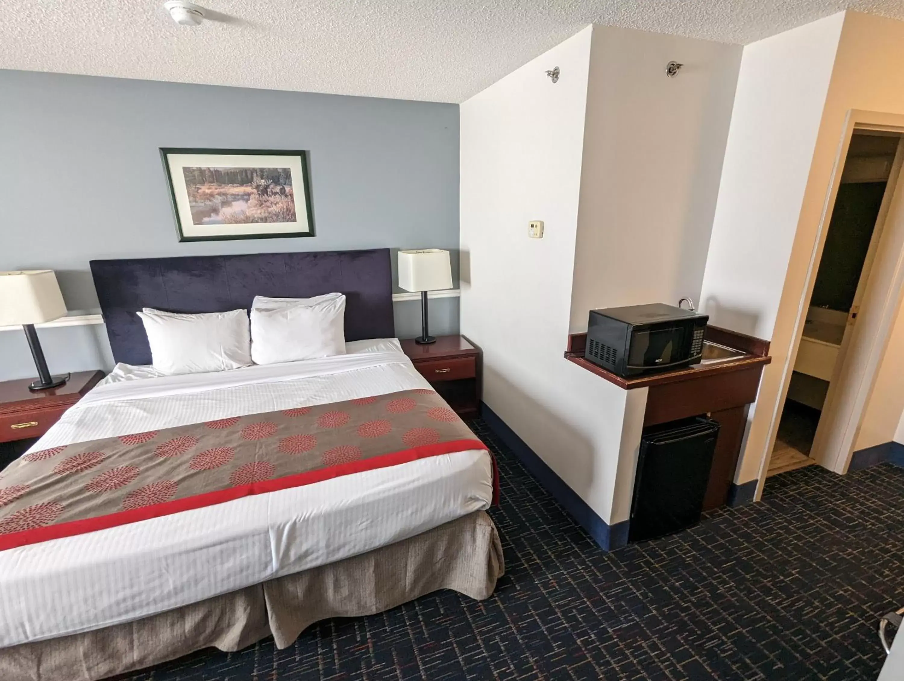 Photo of the whole room, Bed in DIVYA SUTRA Riviera Plaza and Conference Centre Calgary Airport